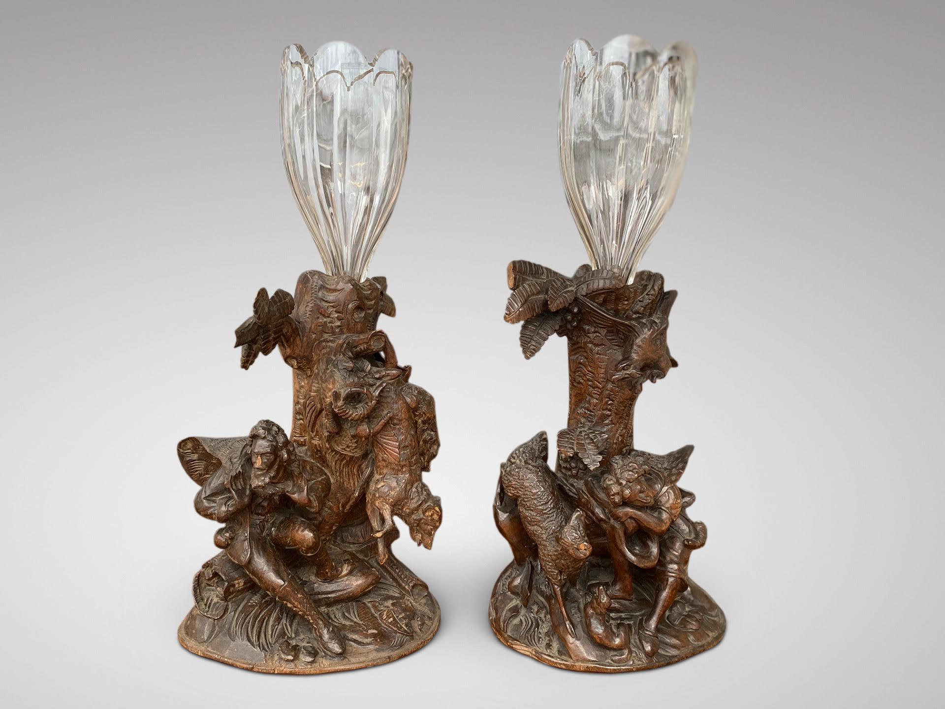 A beautiful pair of 19th century carved wood black forest hunting scene, shaped glass flower vases. In perfect original condition. 

The dimensions are:
Height: 42.5cm (16.7in)
Width: 20cm (7.9in)
Depth: 14cm (5.5in)

This pair of carved wood black