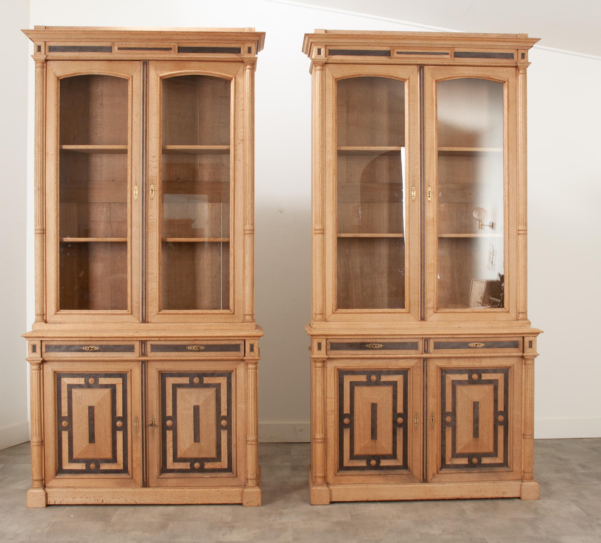 A pair of bleached oak bookcases stand at 8.5 feet tall and make a huge impact together.  The contrast of wood finishes makes it easy to incorporate with your existing decor. Each glass front case houses two adjustable shelves. The lower storage