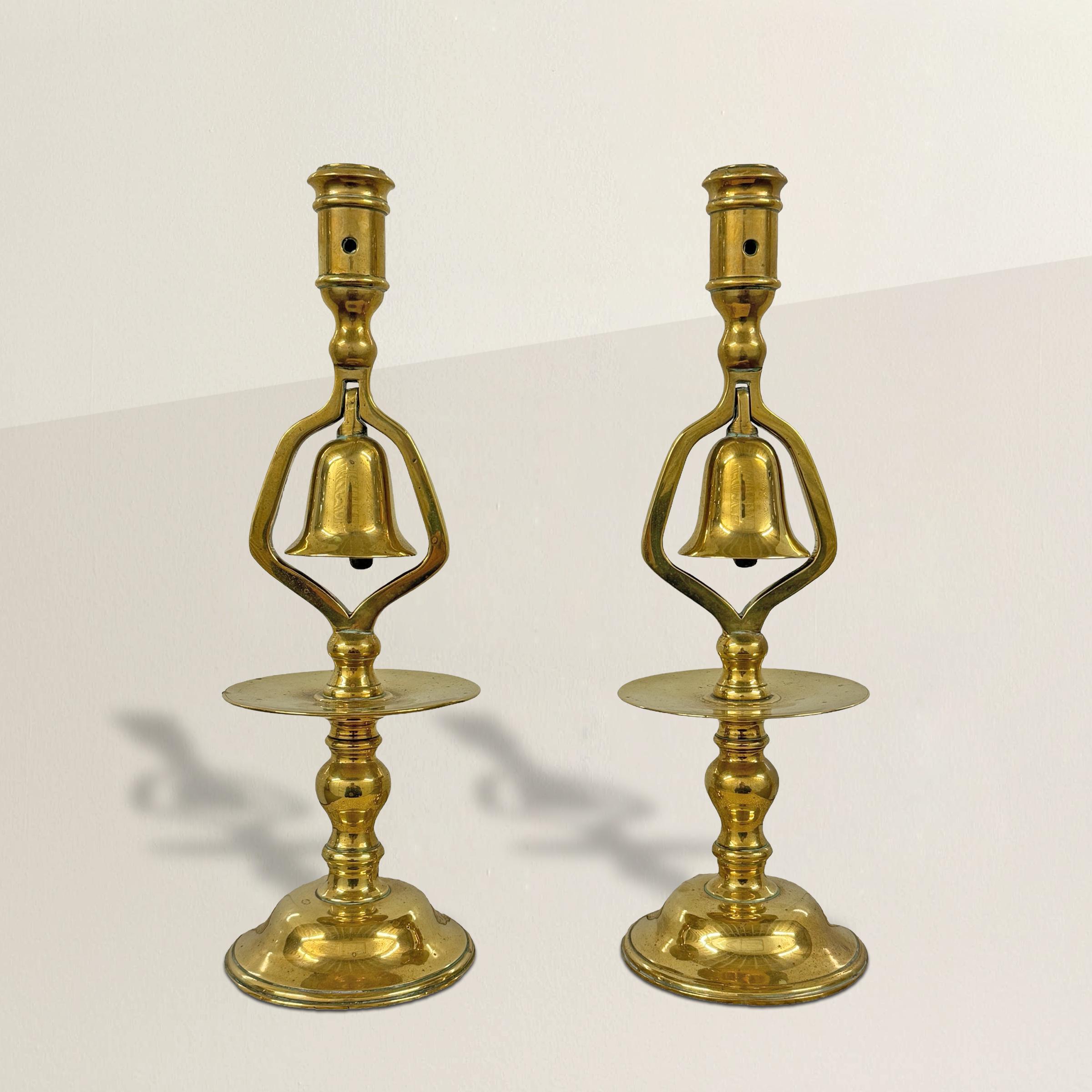 This pair of 19th-century English brass candlesticks embodies the charm and ingenuity of a bygone era. Crafted with meticulous attention to detail, these candlesticks feature bells suspended within their elegantly turned columns, a distinctive