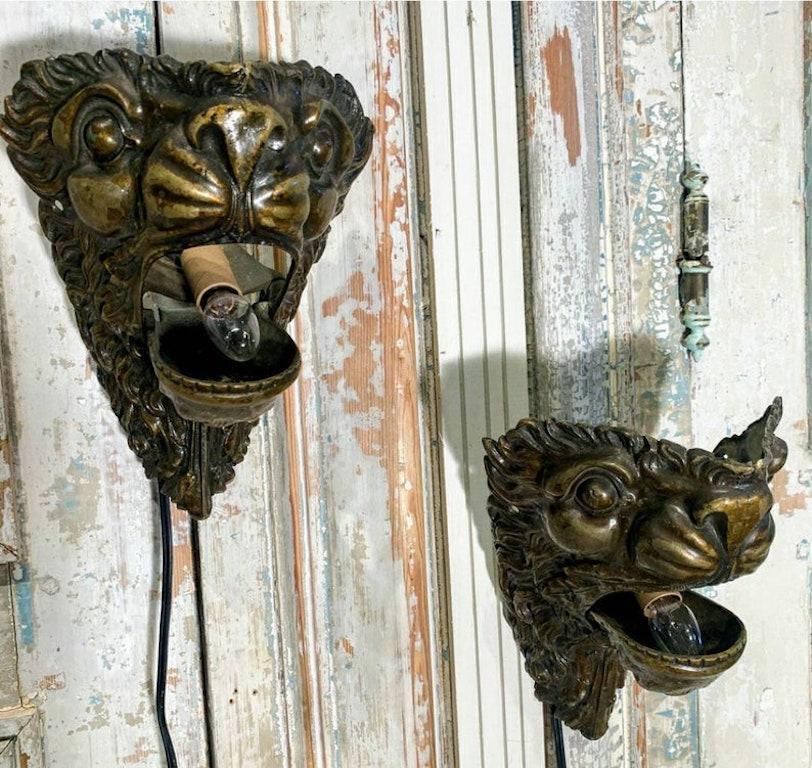 A one-of-a-kind matched pair of antique brass lion head wall sconces, crafted from 19th century pool table ball returns. The good quality, electrified, wall hanging lamps in sconce form, present splendidly, with beautifully aged patina.

What is