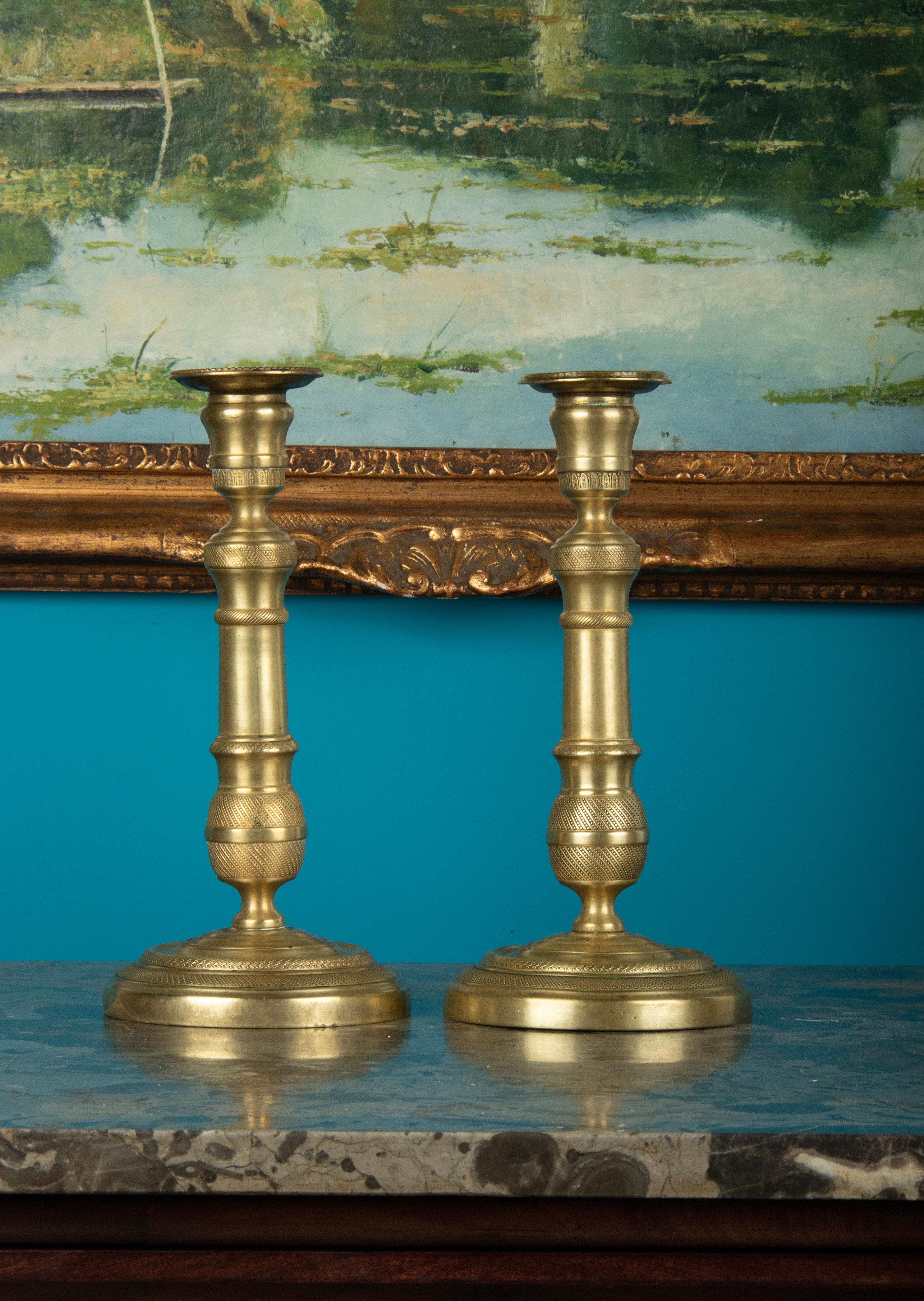 A pair of brass candlesticks. Beautifully decorated with refined silicery in Louis XVI style. The candlesticks date from around 1880-1890, originating from France.