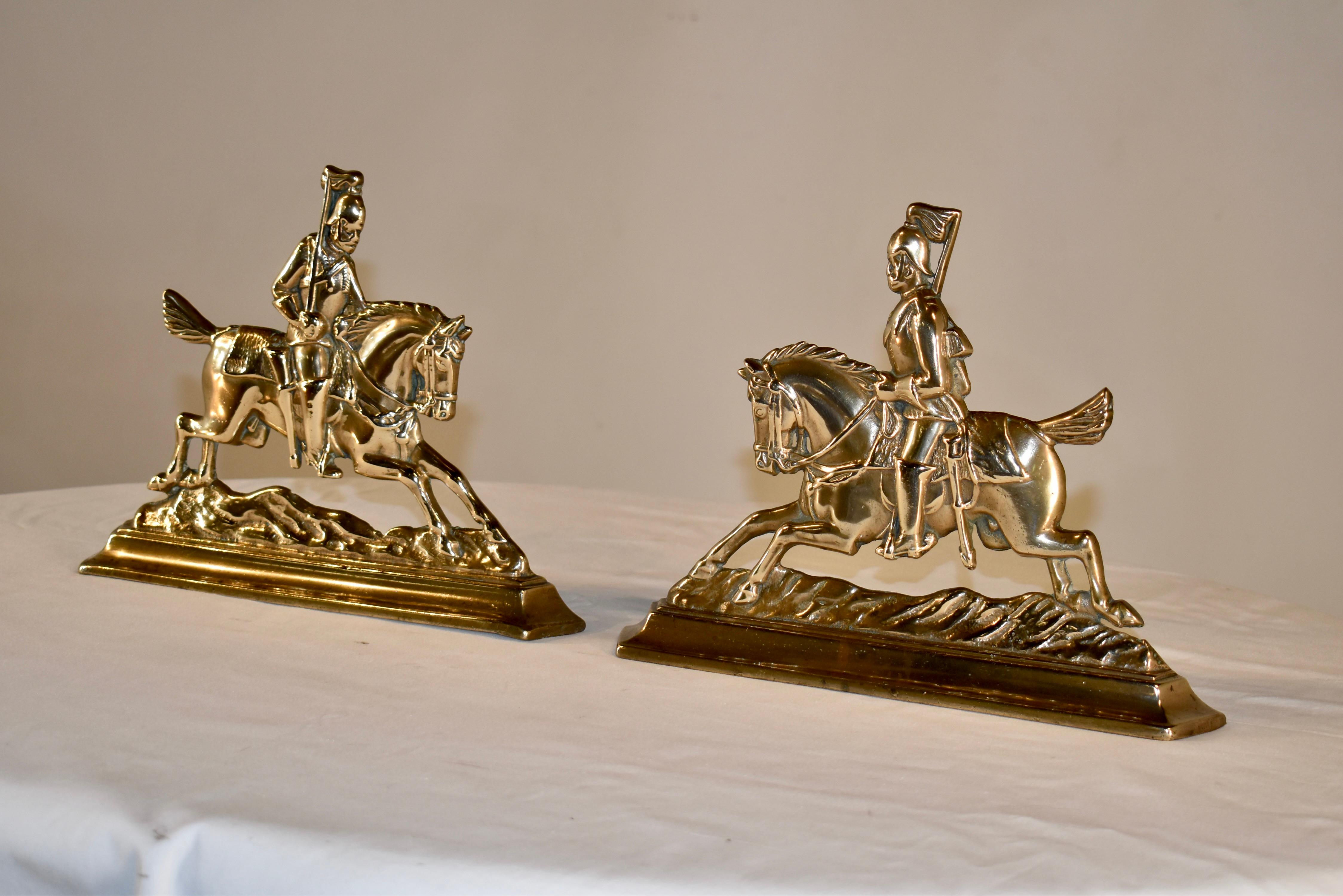 Pair of lovely 19th century brass mantle decorations from England. They are a wonderfully molded pair of soldiers mounted on horseback and holding flags. they look as if the are riding swiftly to carry messages over rough terrain. They have