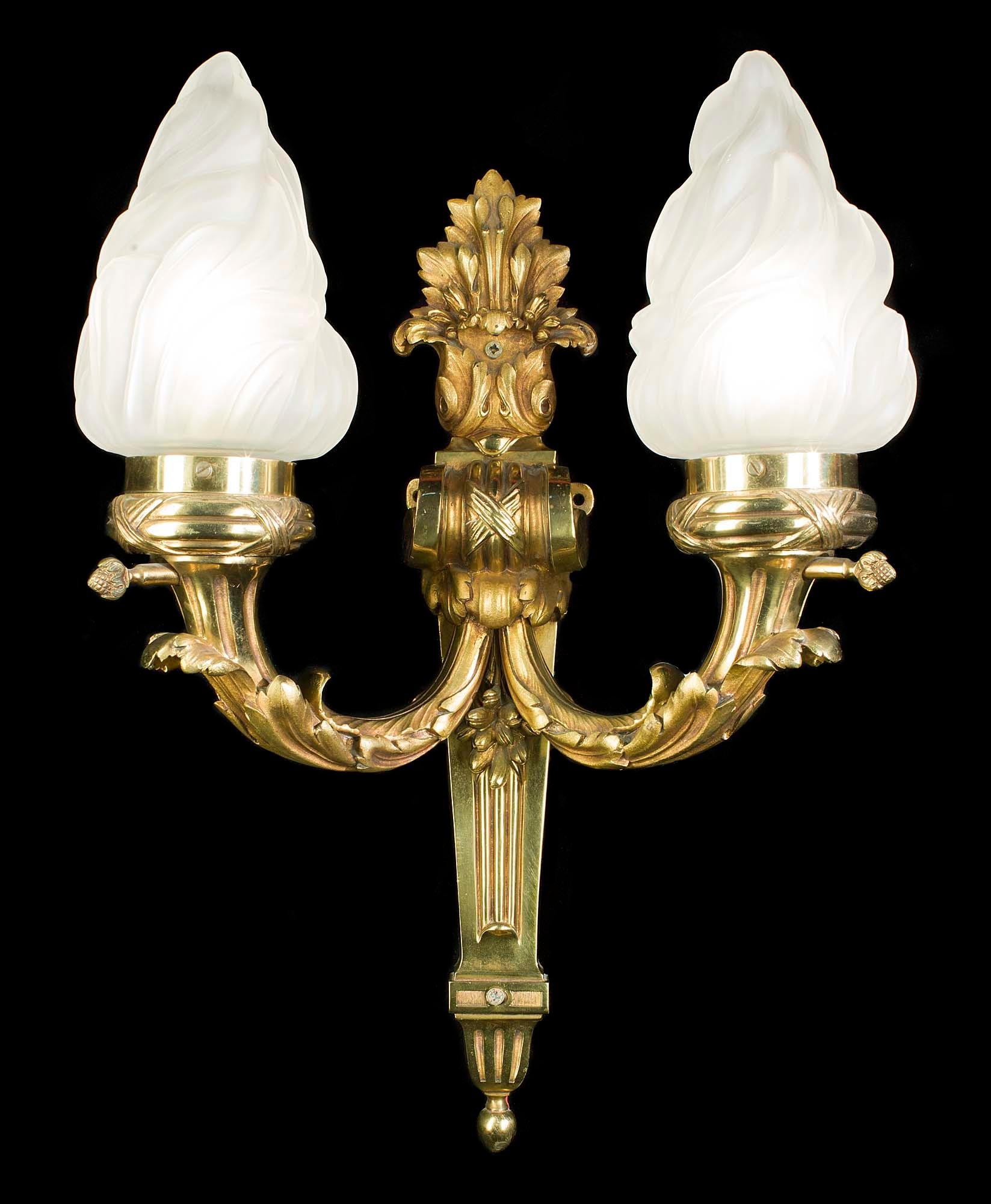 A pair of large Victorian antique brass wall lights in the Baroque style with flambeau glass shades the light controls with pineapple tipped finials. Former gasoliers converted to electricity, English, late 19th century.