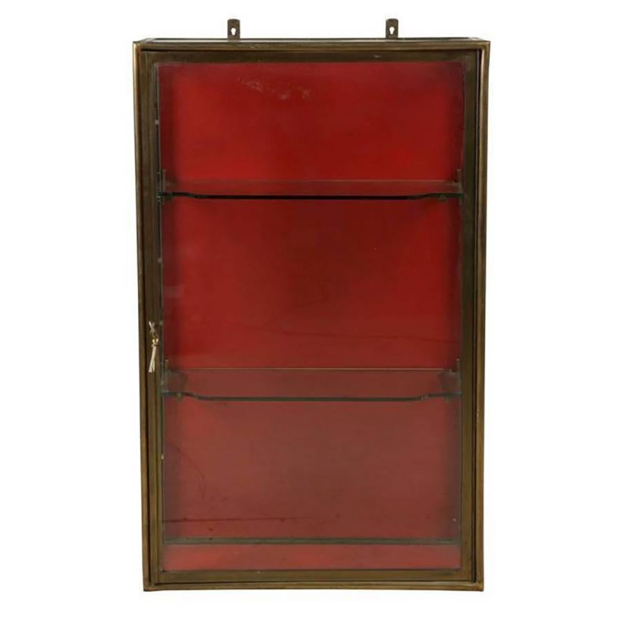 These antique 19th century wall hanging vitrines are made of brass, with a rich red backing which could be repainted to suit any interior decoration scheme. These pieces feature their original curved glass shelves and brackets, and also keys. Each