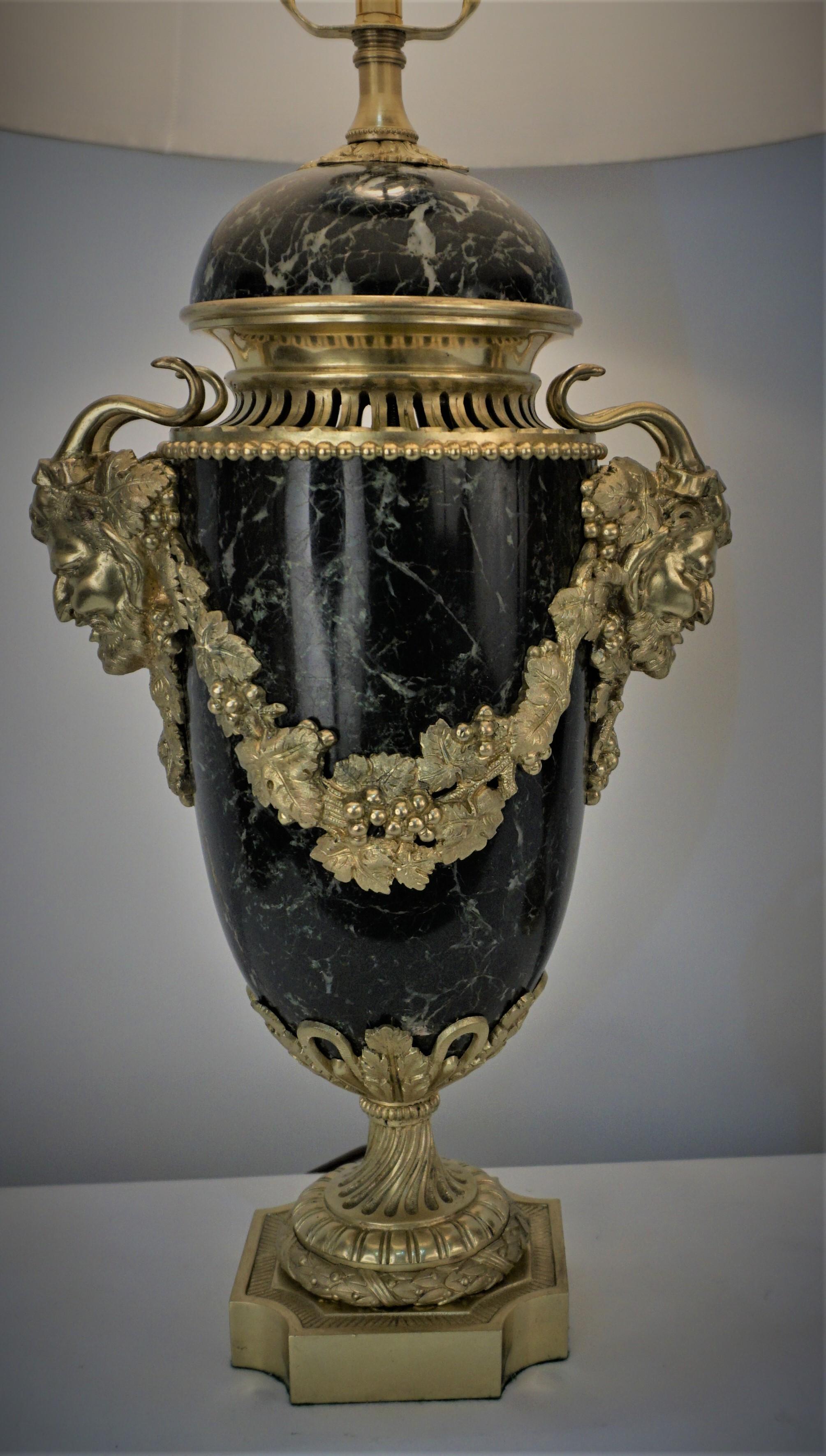 Pair of 19th century marble urns with metrological bronze head of the god on each side that professionally have been electrified as table lamps and fitted with pleated silk lampshades.