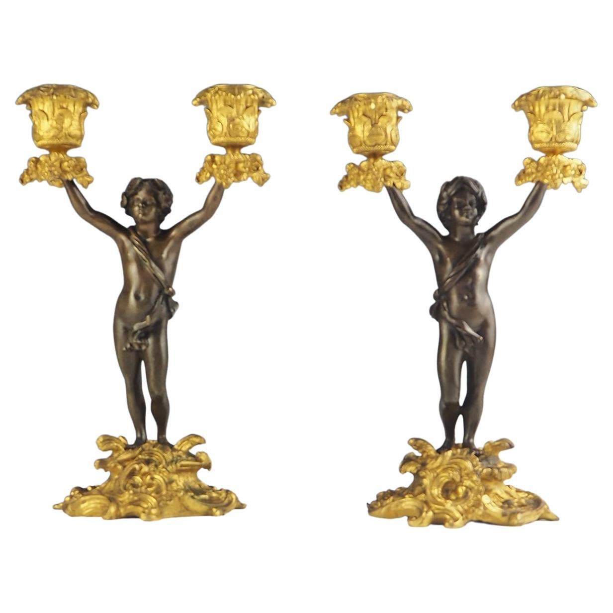 Paar Cherub-Kandelaber aus Bronze und Goldbronze des 19. Jahrhunderts mit zwei Lichtern