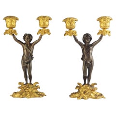 Coppia di candelabri a due luci Cherubino in bronzo e ormolu del XIX secolo