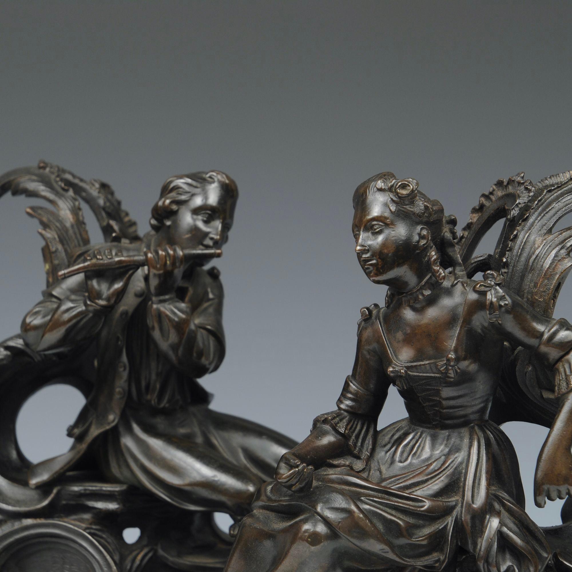 Paire de chenets français décoratifs représentant un couple assis sur des acanthes, l'homme jouant de la flûte.
Milieu du XIXe siècle  