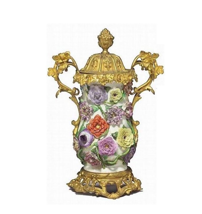 L'article suivant est une paire de rares et importants vases et couvercles en porcelaine européenne à fleurs incrustées, montés en bronze doré, signés d'une fausse marque d'épées bleues croisées. Chacun de forme balustre et appliqué sur l'ensemble