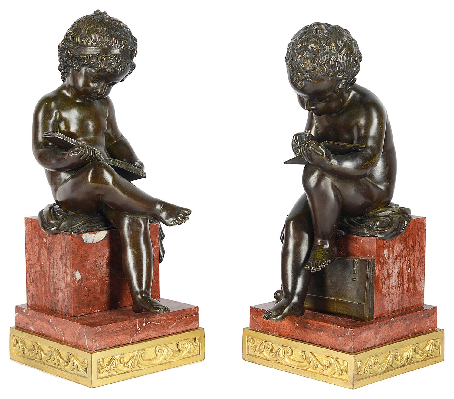 A fine quality pair of 19th century classical bronze seated putti, reading and writing, mounted on square rouge marble plinths and engraved gilded ormolu bases.