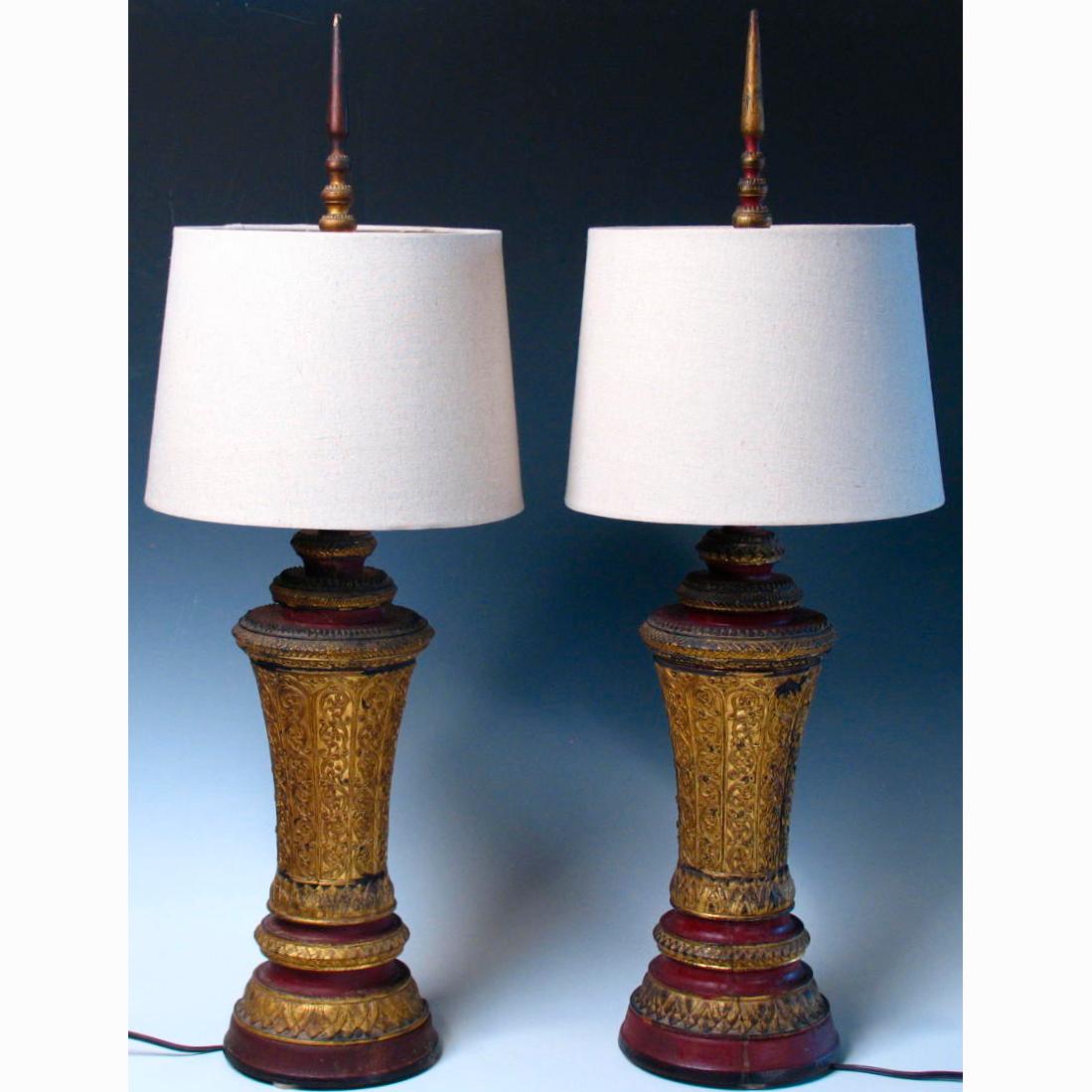 Pair of Cambodian wood urns, the body of turned wood with assembled multitiered finial lid, decorated in raised lacquer with lotus and scrolling vine designs in red and black with gold leafed segments. Originally used as votive altar pieces in a