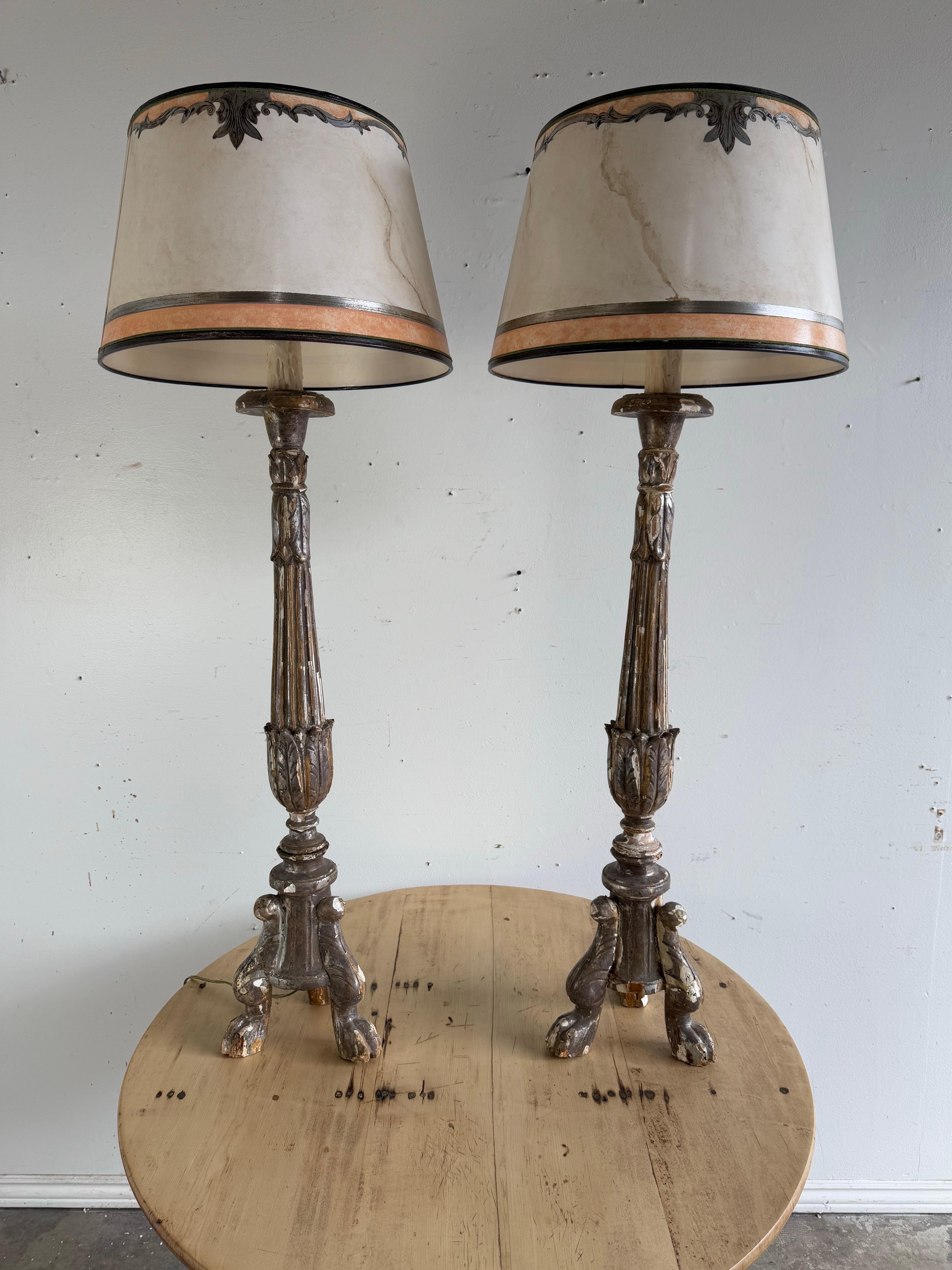 Paire de chandeliers italiens en bois doré du 19e siècle transformés en lampes.  La paire de chandeliers est très ornée, avec des détails sculptés qui ressemblent à des colonnes cannelées avec des motifs de feuilles d'acanthe et de volutes.  Chaque