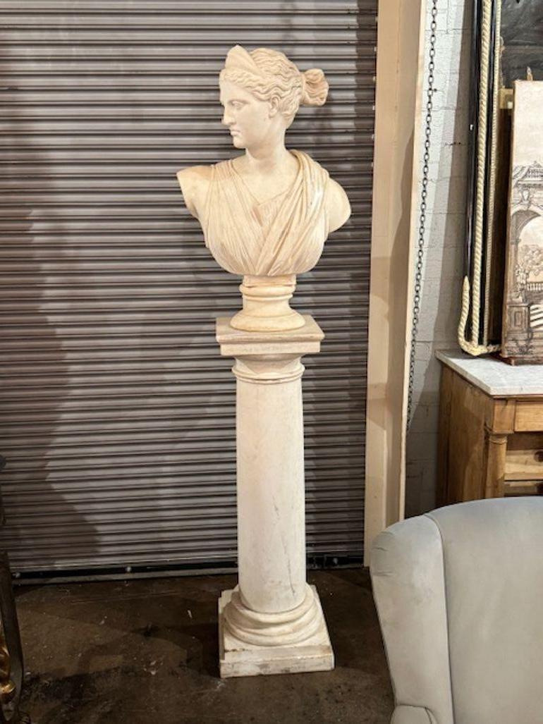 The product is a pair of 19th Century Carrara Marble Busts featuring depictions of Apollo and Diana displayed on pedestals. These sculptures are presented in a Bust format, showcasing intricate details and craftsmanship typical of sculptures from