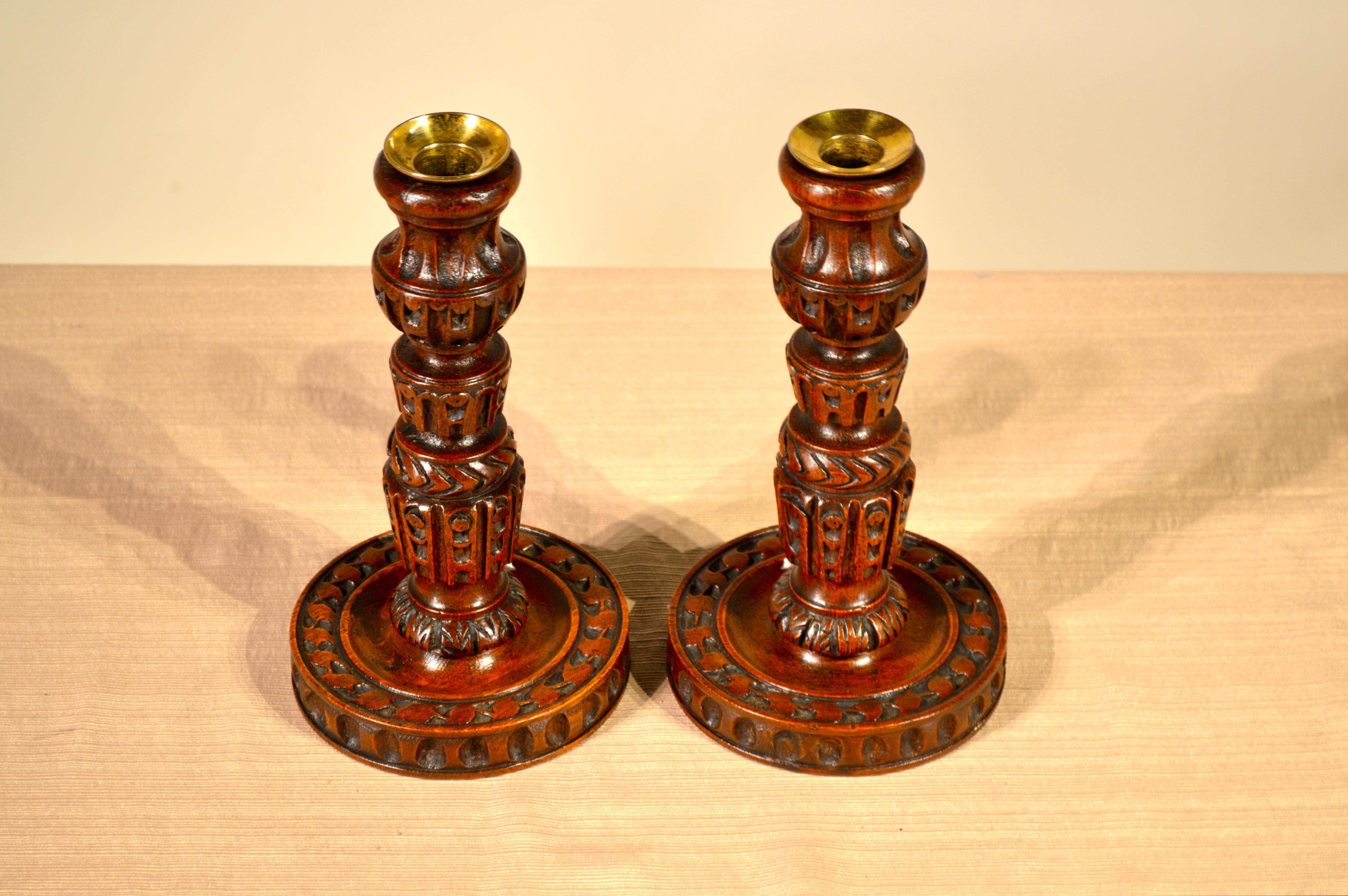 19th century pair of English candlesticks which are turned and decorated completely with hand-carved decoration.
