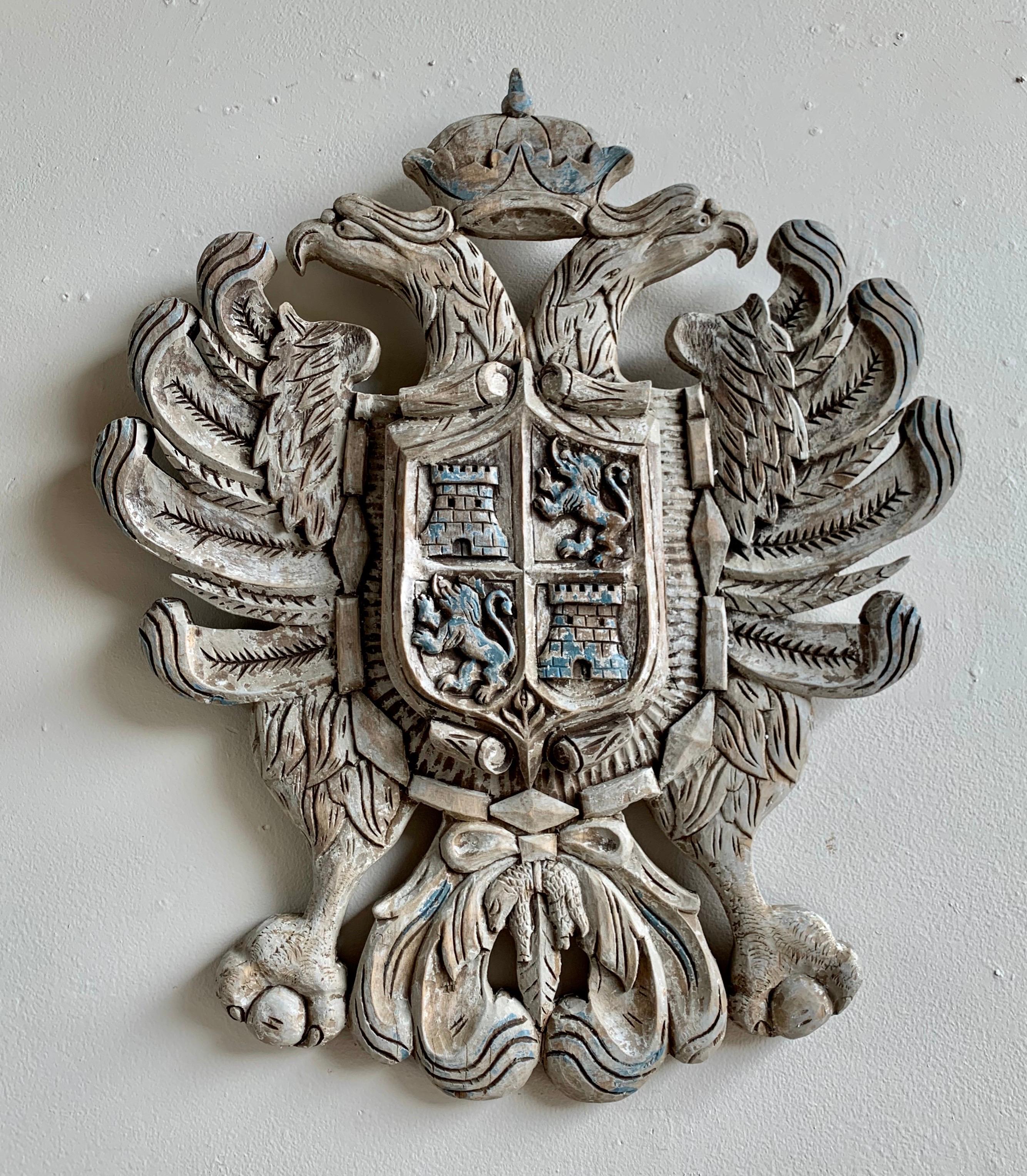 Pair of similar 19th century hand carved English coat of arms. The carvings depict a two-headed eagle with the royal crown. Remnants of paint can still be see throughout. They are not an exact pair as they are both hand carved but they have been