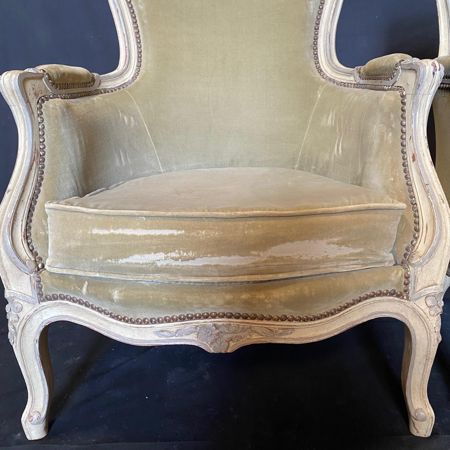 Really lovely all original soft moss green period Louis XV mohair armchairs or bergeres. All original creamy white paint that perfectly complements the luxurious moss green mohair. Floral wreath carving on center top and apron of the chair, all
