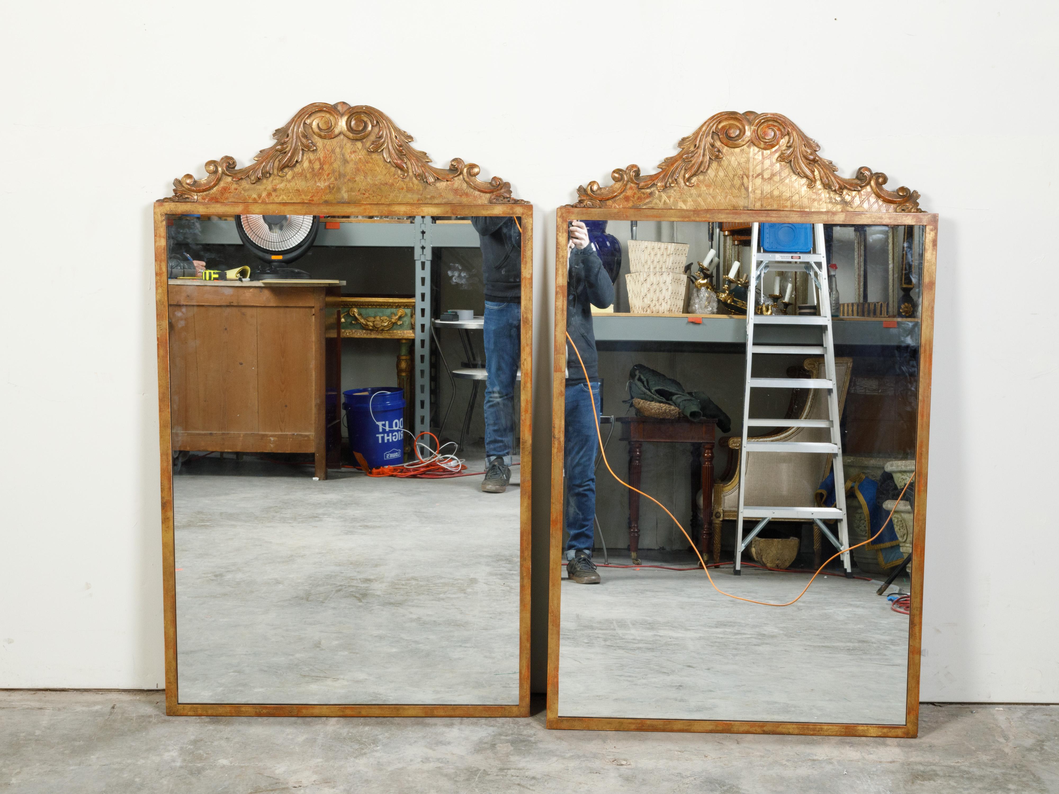 A pair of carved giltwood architectural fragments from the 19th century, mounted on custom gilt metal frames. This pair of mirrors, made of 19th century architectural fragments mounted on custom metal frames, draw our attention with their scrolling