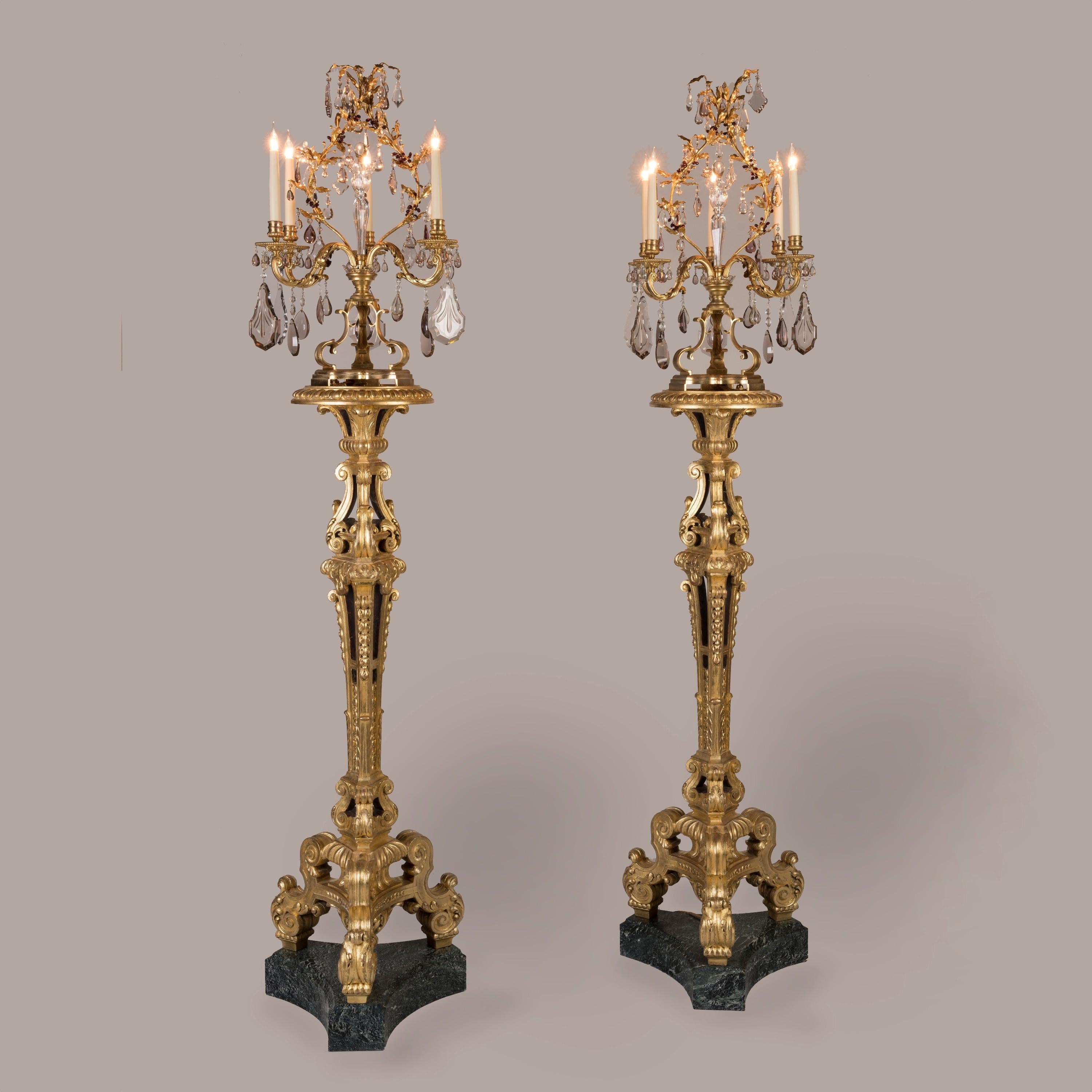 A Pair of Giltwood Carved Torchères

After the Design by Jean Pelletier
for the King's State Apartments

Supported on incurved tripartite plinths, the pair of torchères hand-carved in the French style, with three scrolled legs and a triangular