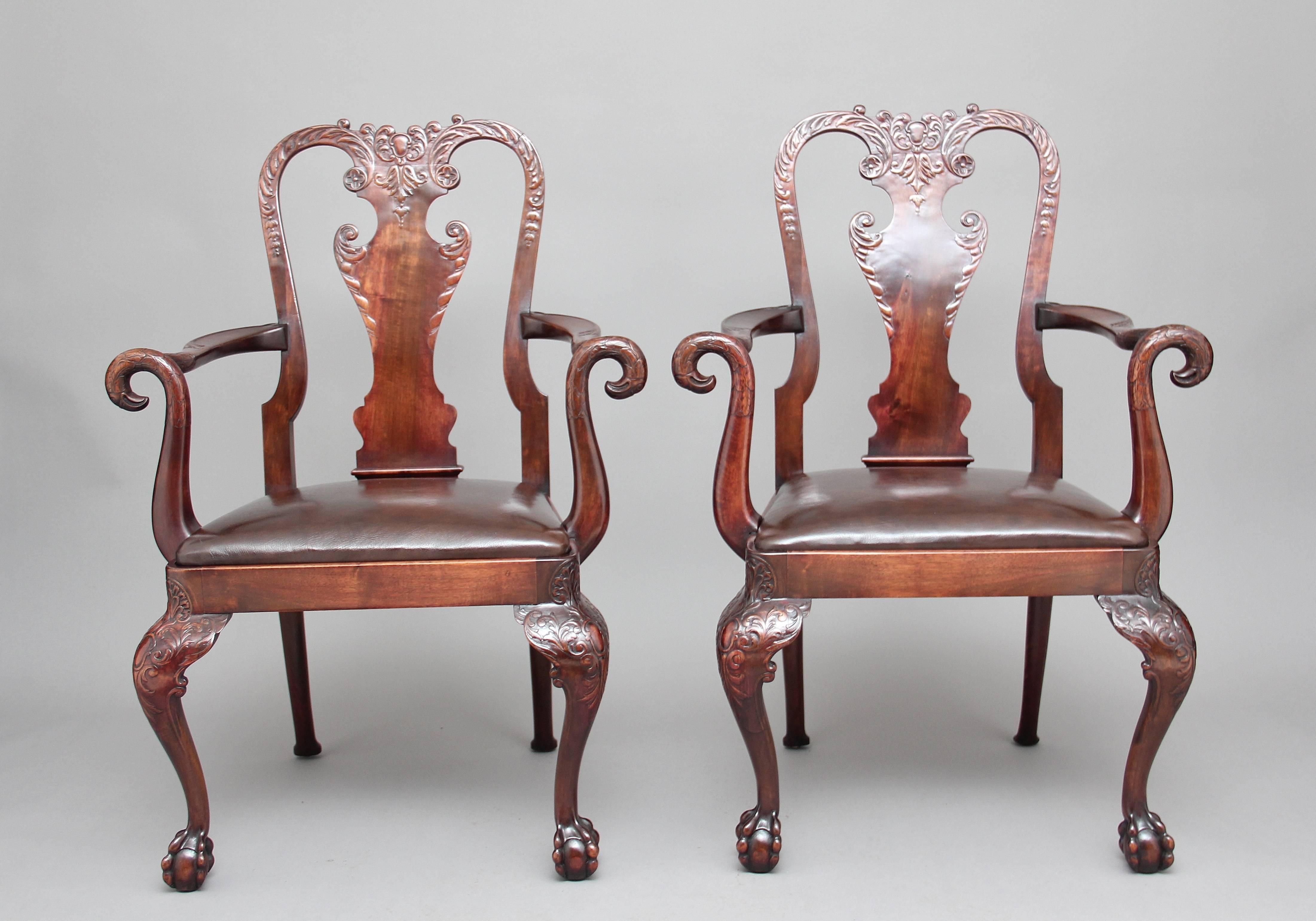 A remarkable pair of 19th century mahogany armchairs in the 18th century style, with an ornate carved back with a central vase shape with carved scroll decoration, with elegant carved arm supports with stylized birds heads, a brown leather drop in
