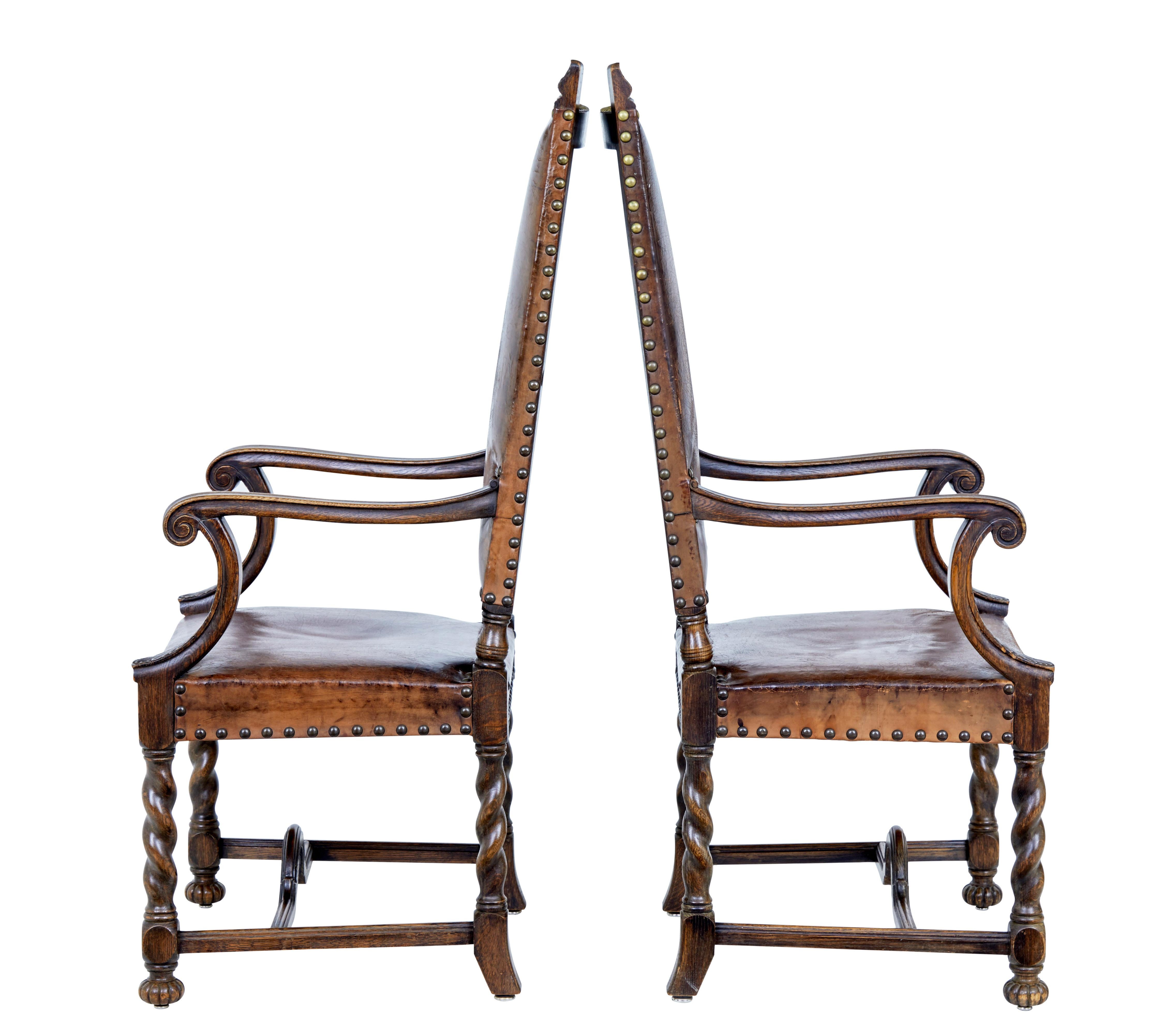 Imposing pair of high back carved oak armchairs, circa 1880.

Dark oak which has taken on great patina along with the original leather. Carved scrolling arms supported by an acanthus leaf detail. Standing on barley twist legs united by a horseshoe