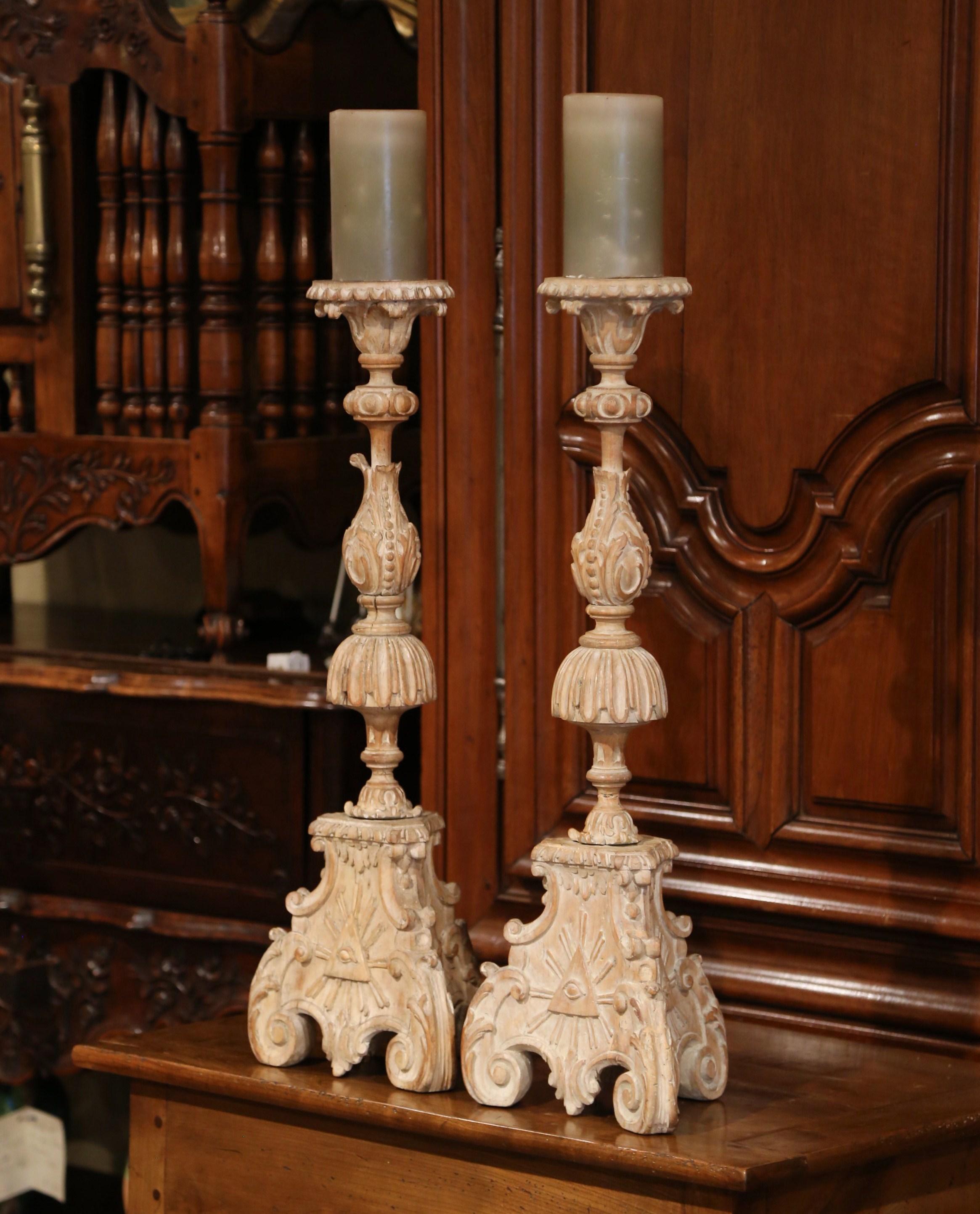 These elegant carved fruitwood Pic-Cierges were probably created in France or Italy, circa 1870. Sitting on three small Louis XV scroll feet, the tall antique candlesticks features a three-side base with the Eye of Providence carving on all three