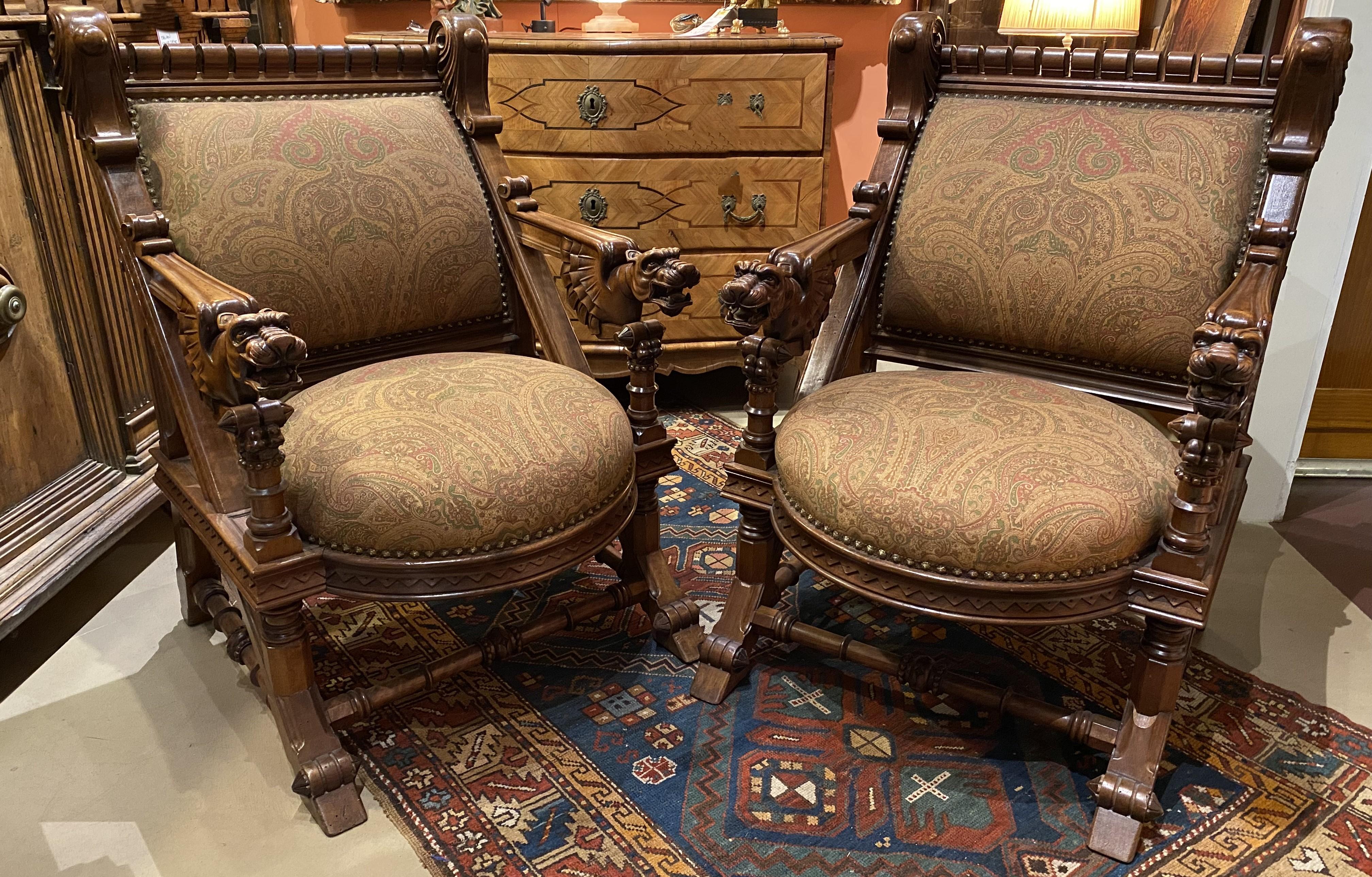 A fine pair of walnut heavily carved arm chairs with griffin arms and fresh Paisley upholstery in browns and reds, with beautiful scrolled & geometric detail. The chairs date to the late 19th century and are in very good condition, with minor