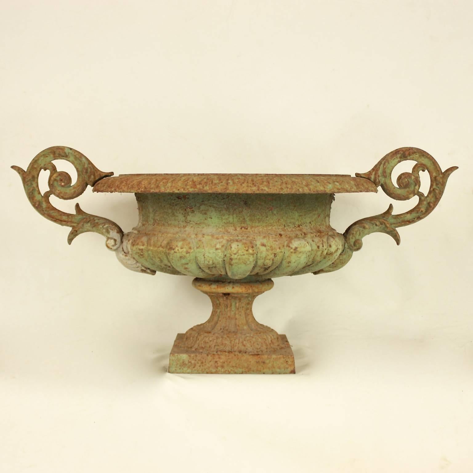 Beautiful pair of cast iron jardinieres, so-called 'Vases Chambord' on shallow fluted feet, with gadrooning at the lower body, a leave rim and scrolled foliate handles. Remains of green paint perfectly brightens up the wonderful old weathered