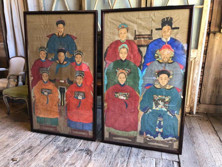 A nice pair of Chinese ancestor family group portraits, 19th century, on paper, framed in teak frames under glass. Twelve characters total in period attire with hats and crowns signifying rank and status.