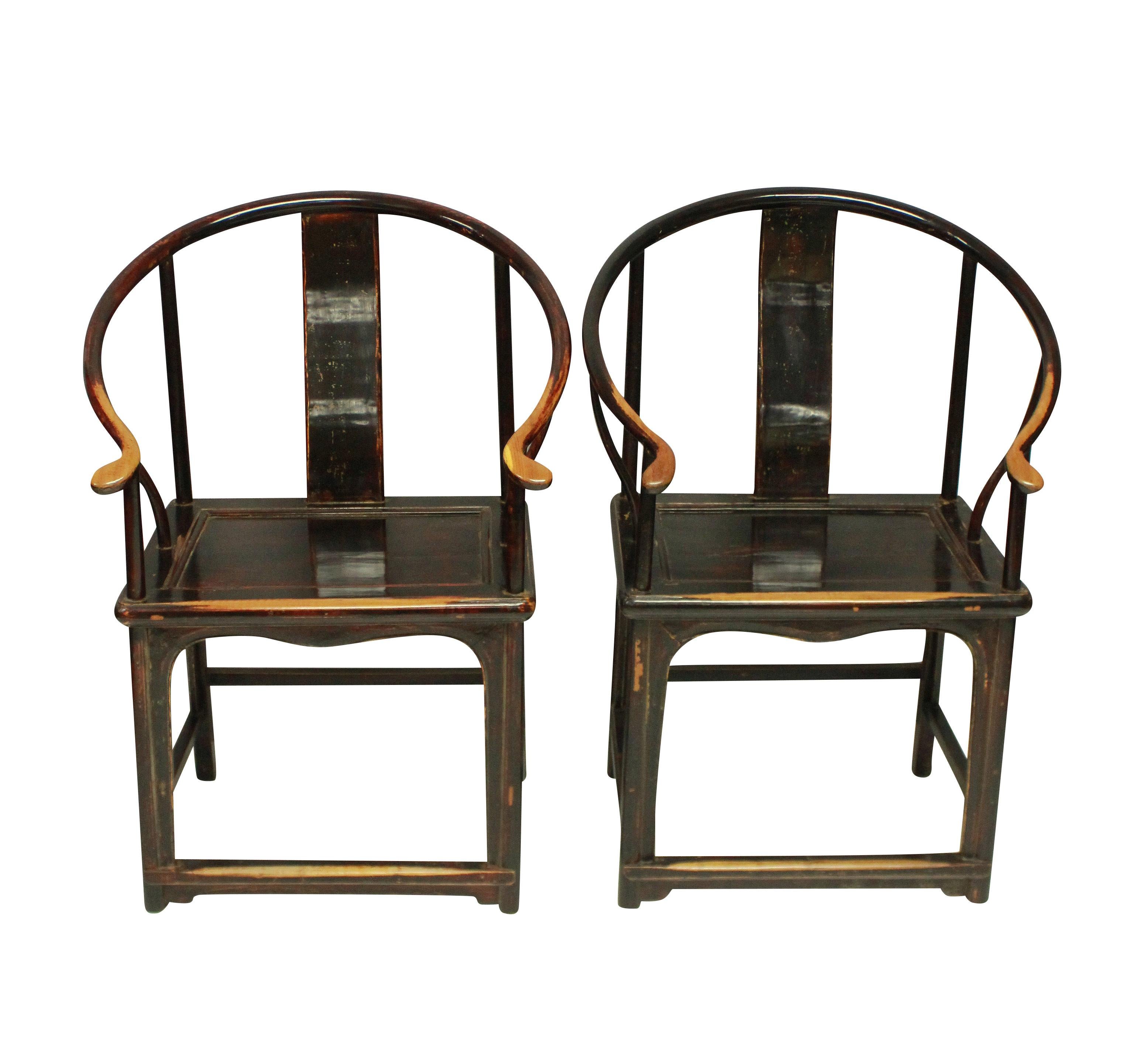 A pair of 19th century Chinese horseshoe armchairs in lacquered elm. With beautiful patina and in their original paints.