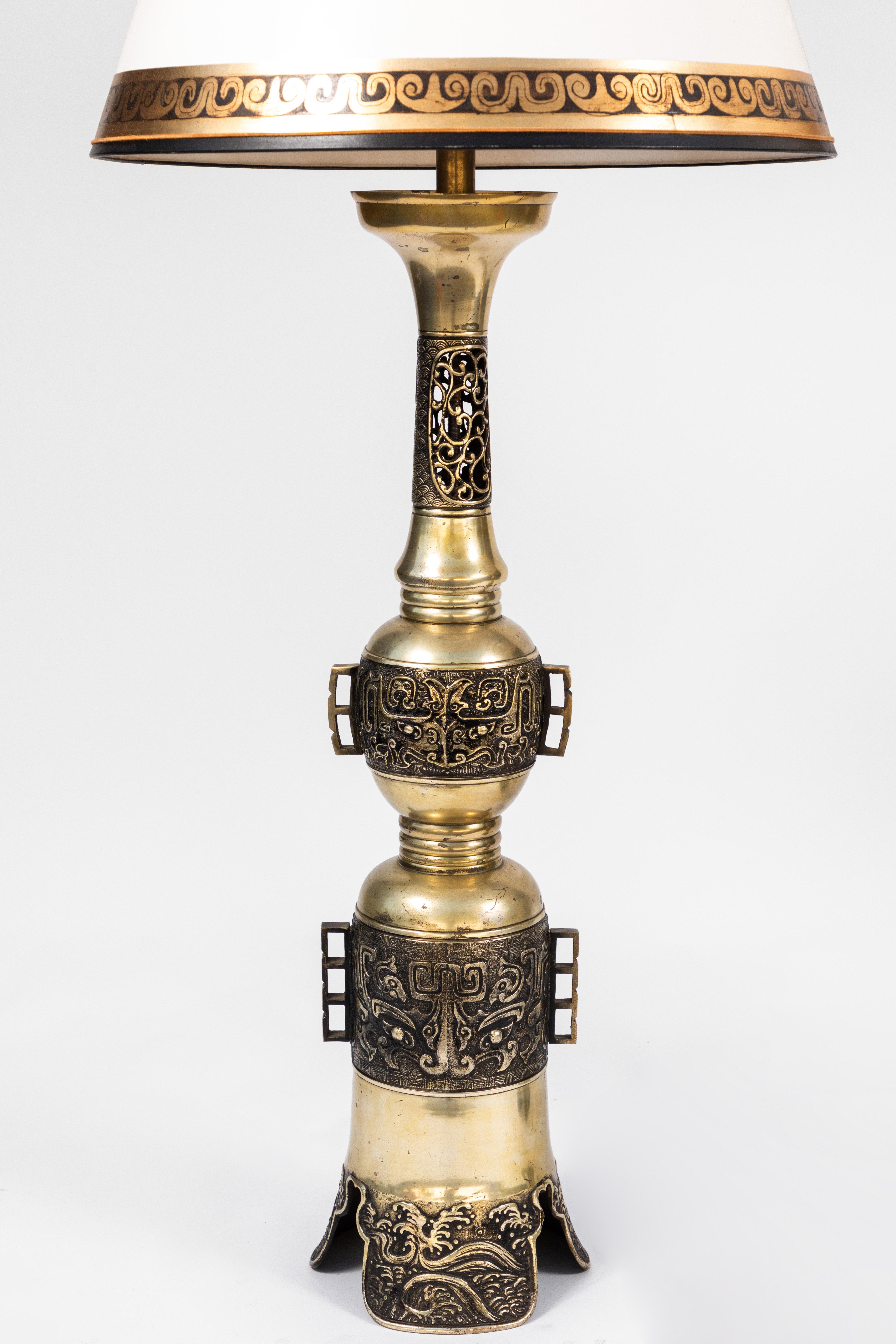 Pair of 19th century Chinese bronze altar stick lamps with custom parchment shades with gilt detail. Newly re-wired.