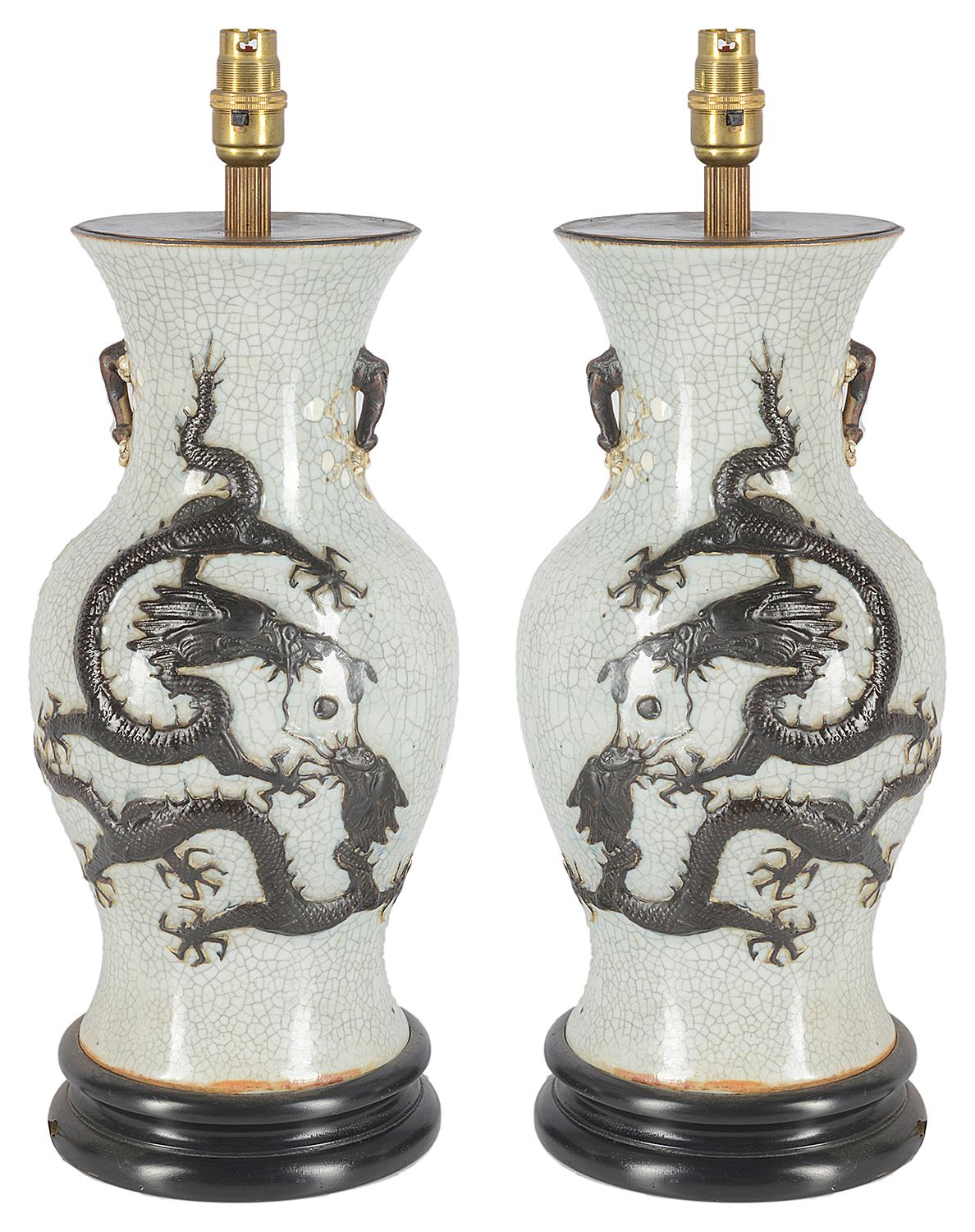 Pair of late 19th century Chinese crackleware vases or lamps. Each having a white ground with a mythical dragon in releaf.