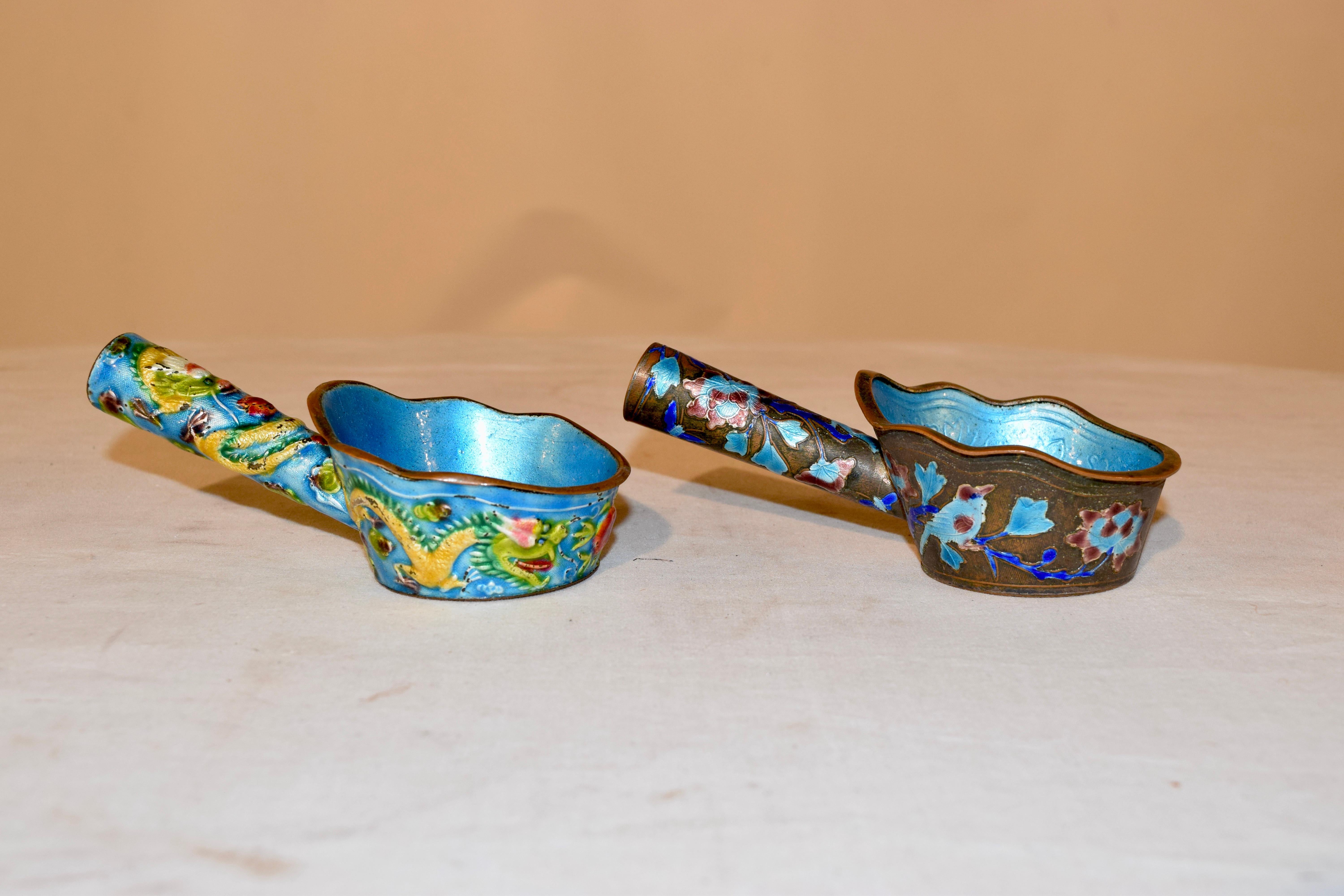 Pair of late 19th century antique copper water dipping or sauce ladles which are very ornate. they are hand enameled with dragons, flowers and an angel-like figure on one handle. The handles are decorated as well. The background is a blue glaze