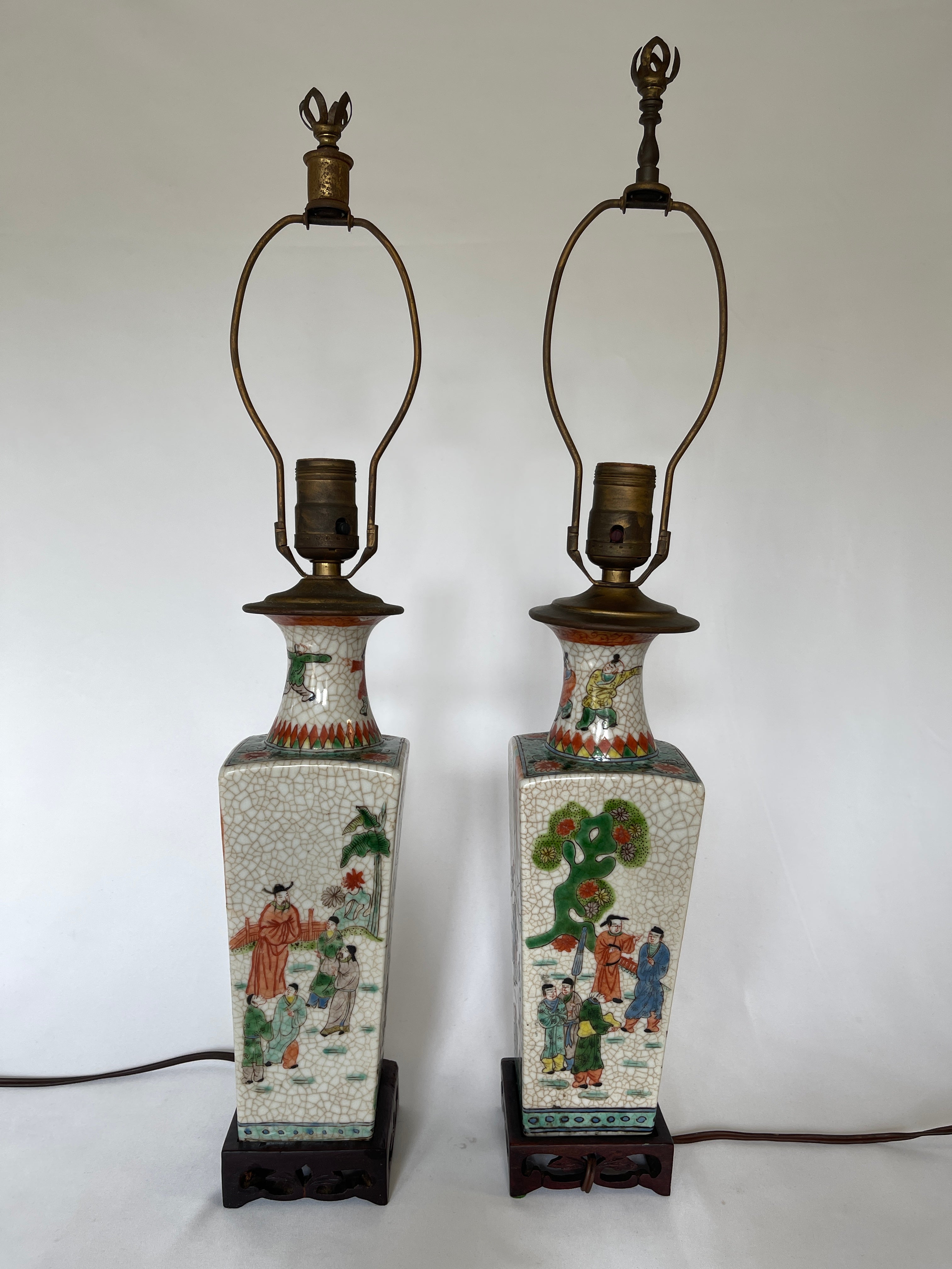 Pair of 19th century Chinese Export crackle ware vase lamps on carved hardwood square bases. Entirely hand decorated, each slightly different from the other. 
The lamps retain original wiring with bakelite switches, and need rewiring.
Lamp body from