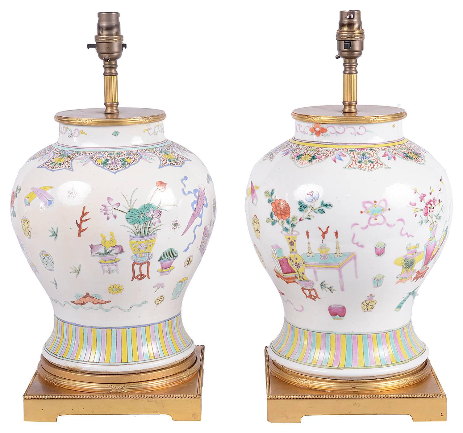 A very decorative pair of late 19th century Chinese Famille rose vases / lamps. Each having various vases, flowers and motif decoration, mounted in gilded ormolu tops and molded bases.