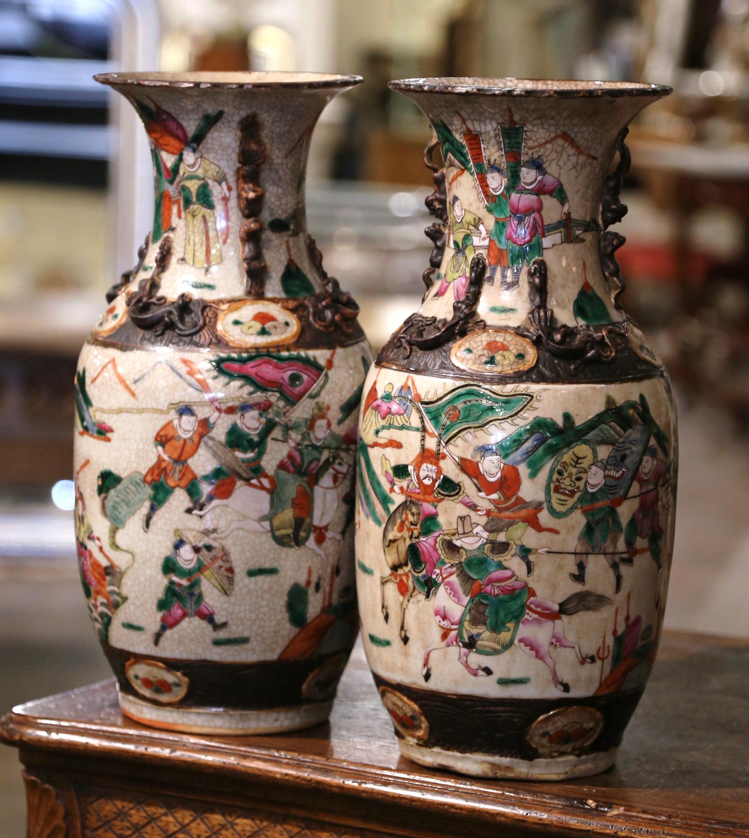 Decorate a table or a console with this pair of colorful antique porcelain vases. These elegant colorful vases were created in China circa 1880. The large vessels with flared rim and tapered body, are decorated with lizard and foo dog motifs around