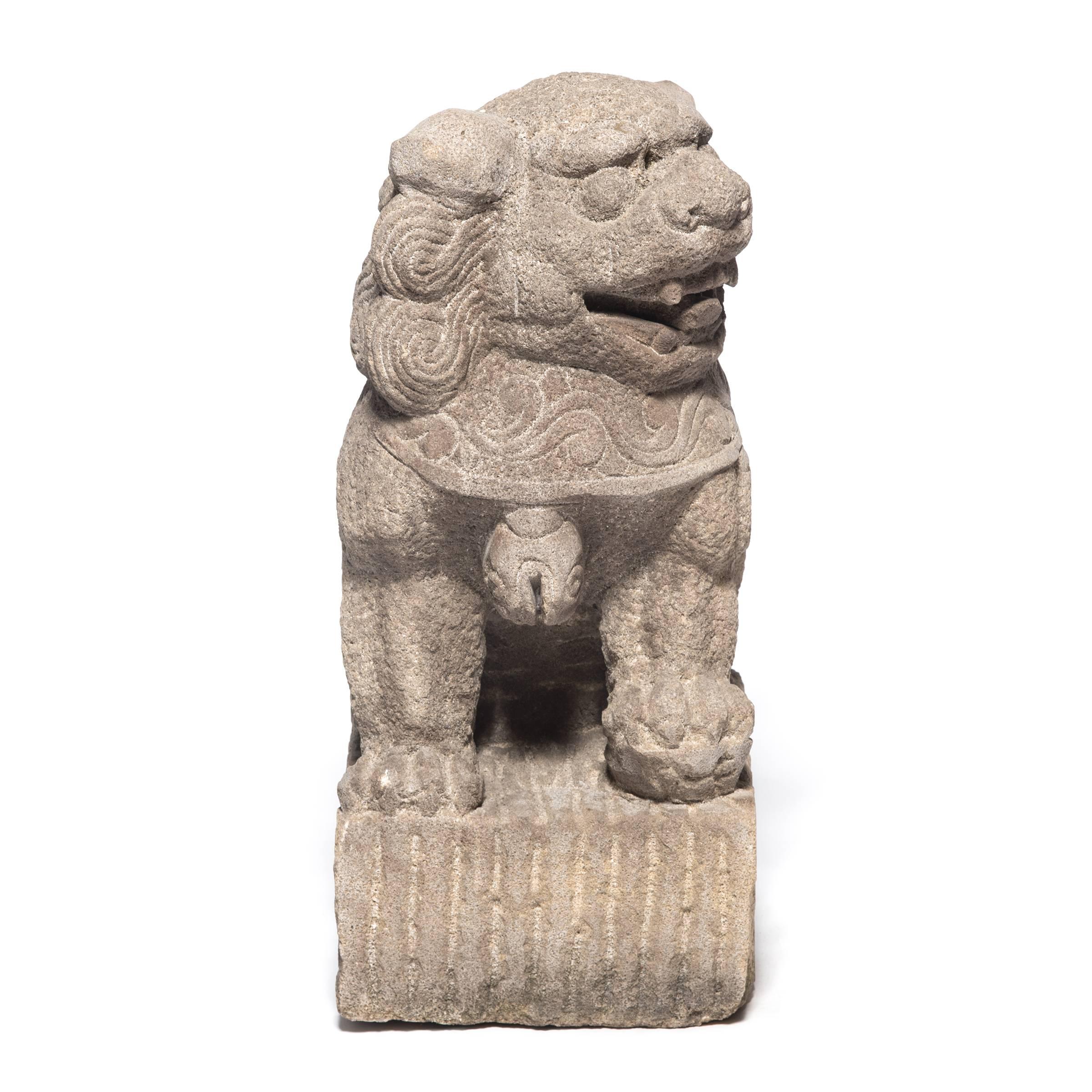 These 19th century Chinese Fu dog protectors, each carved by hand from a single block of limestone, once guarded the entrance to a grand provincial Chinese home. Bells hanging from collars around their necks indicate that the pair has been