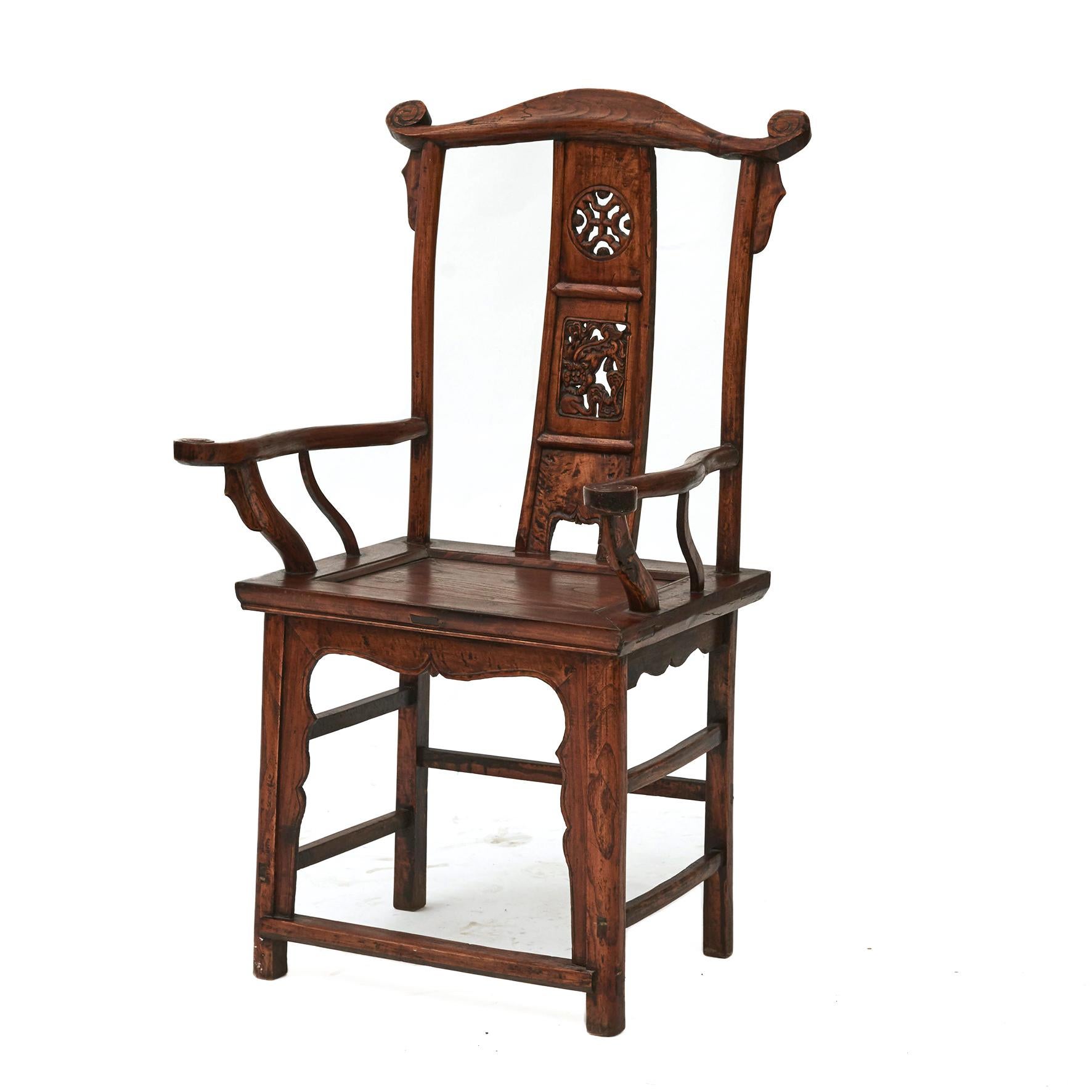 Pair of Chinese yoke back official's hat chairs in ming style.
Created in elm wood in the 19th century each chair features intricate carvings of traditional Chinese motifs on the back splat, including a Foo dog. 
From Shanxi Province,