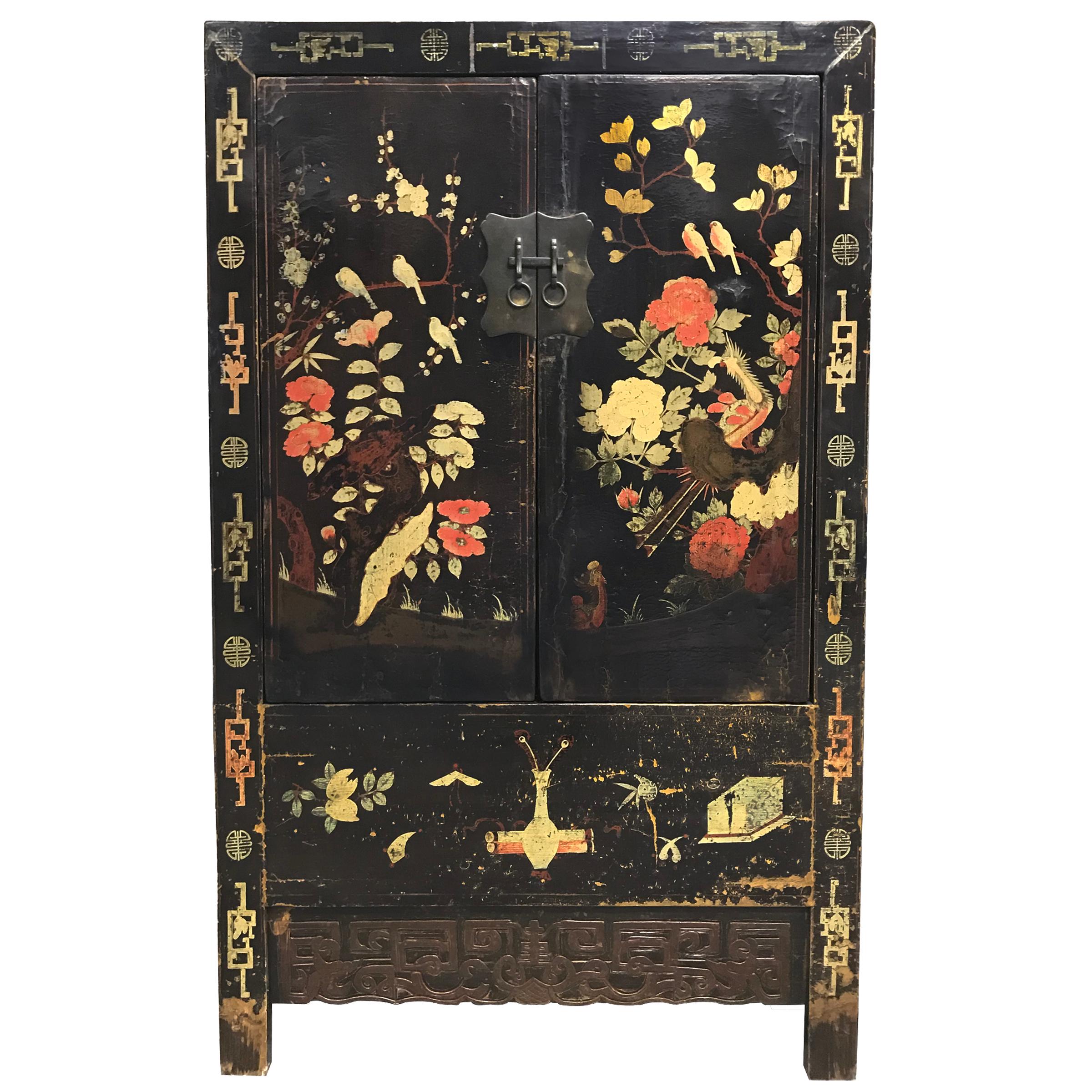 A wonderful pair of 19th century Chinese cabinet with a heavy black lacquer and beautifully painted garden scenes depicting myriad birds including cranes, phoenix, magpies, and ducks amidst a lush landscape of auspicious flowers including peonies,