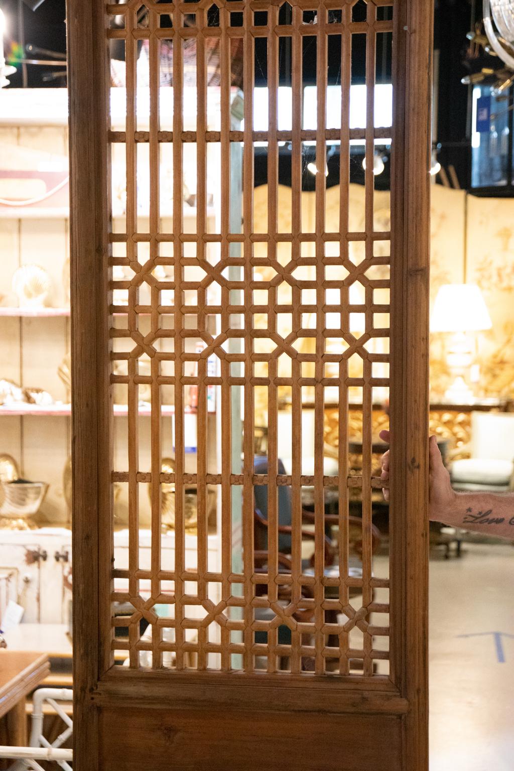 Pair of salvaged Chinese painted pinewood doors with panels of latticework tracery along with Chinese script detailed on one of the smaller rectangular door panels, circa 19th century. Made in China. Please note of wear consistent with age including