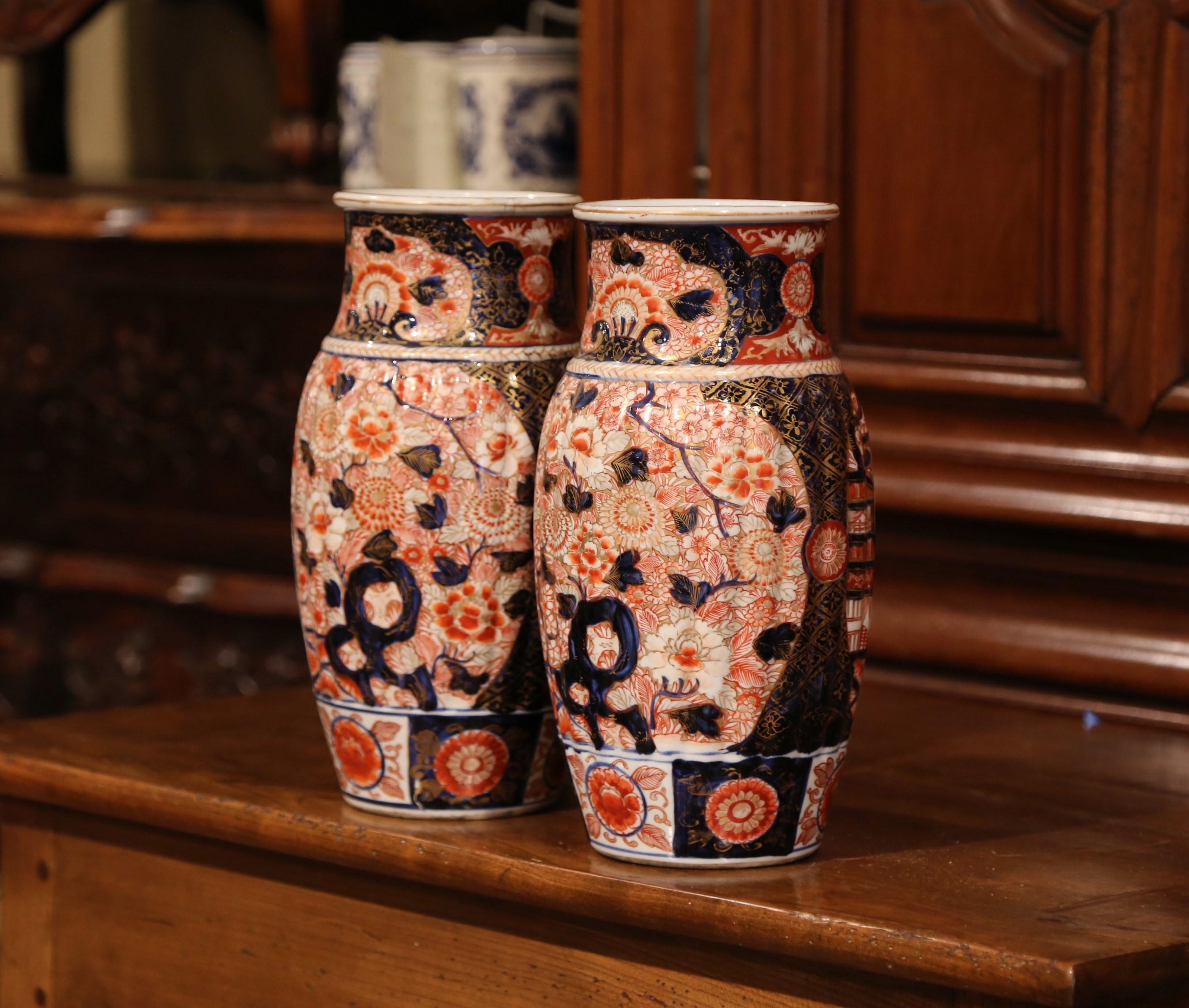 Decorate a mantel or a buffet with this colorful pair of antique Imari vases, crafted in Japan, circa 1880, the handcrafted porcelain vases are signed on the bottom and feature hand painted decor of flowers, leaves and butterflies in the blue,