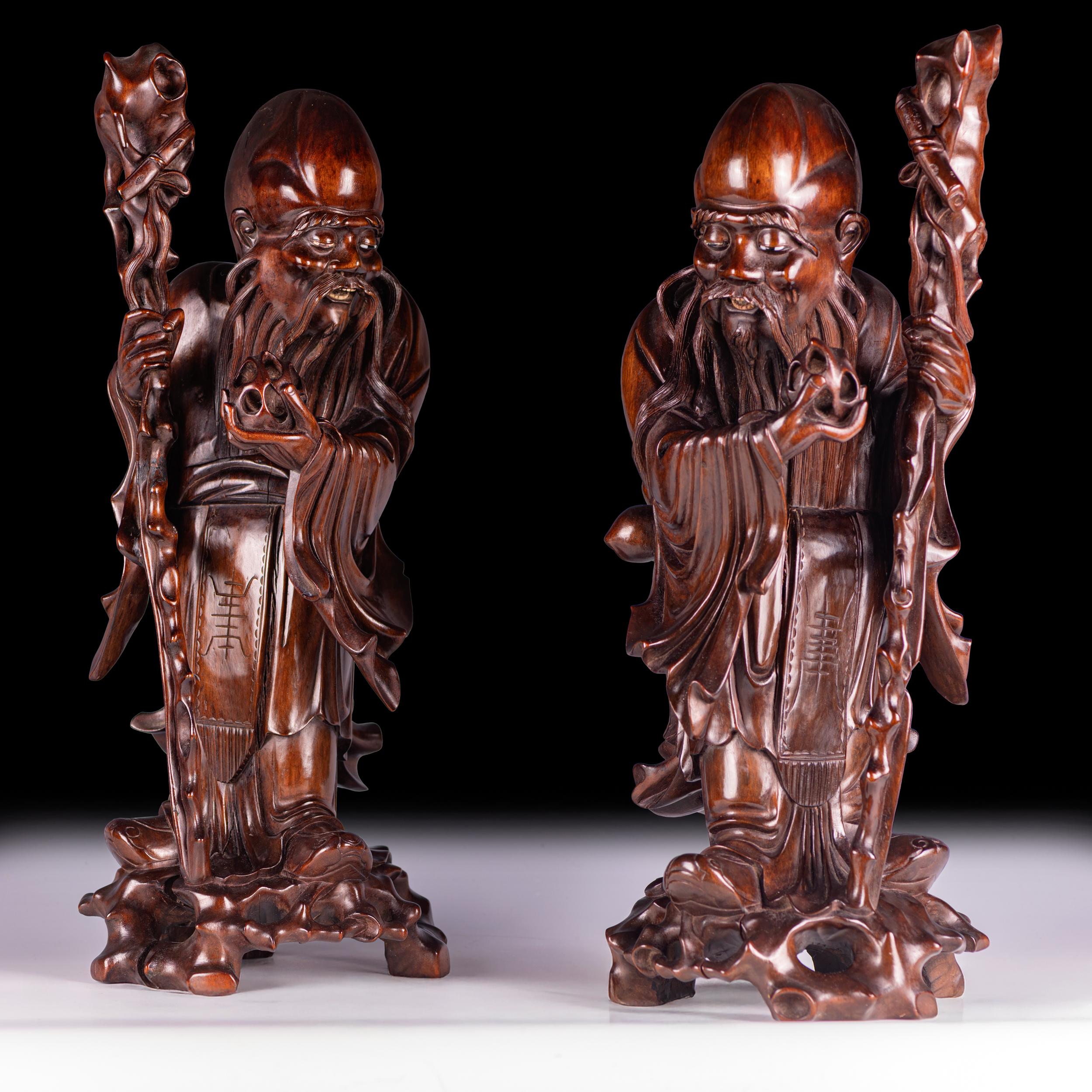 Paire de figurines d'immortels en bois dur de Chine
Dynastie Qing, 19e siècle

Superbe paire de figures immortelles chinoises de lettrés ou de taoïstes, chacune finement sculptée dans un bois dur dense et lustré - probablement du Zitan ou du Hongmu.