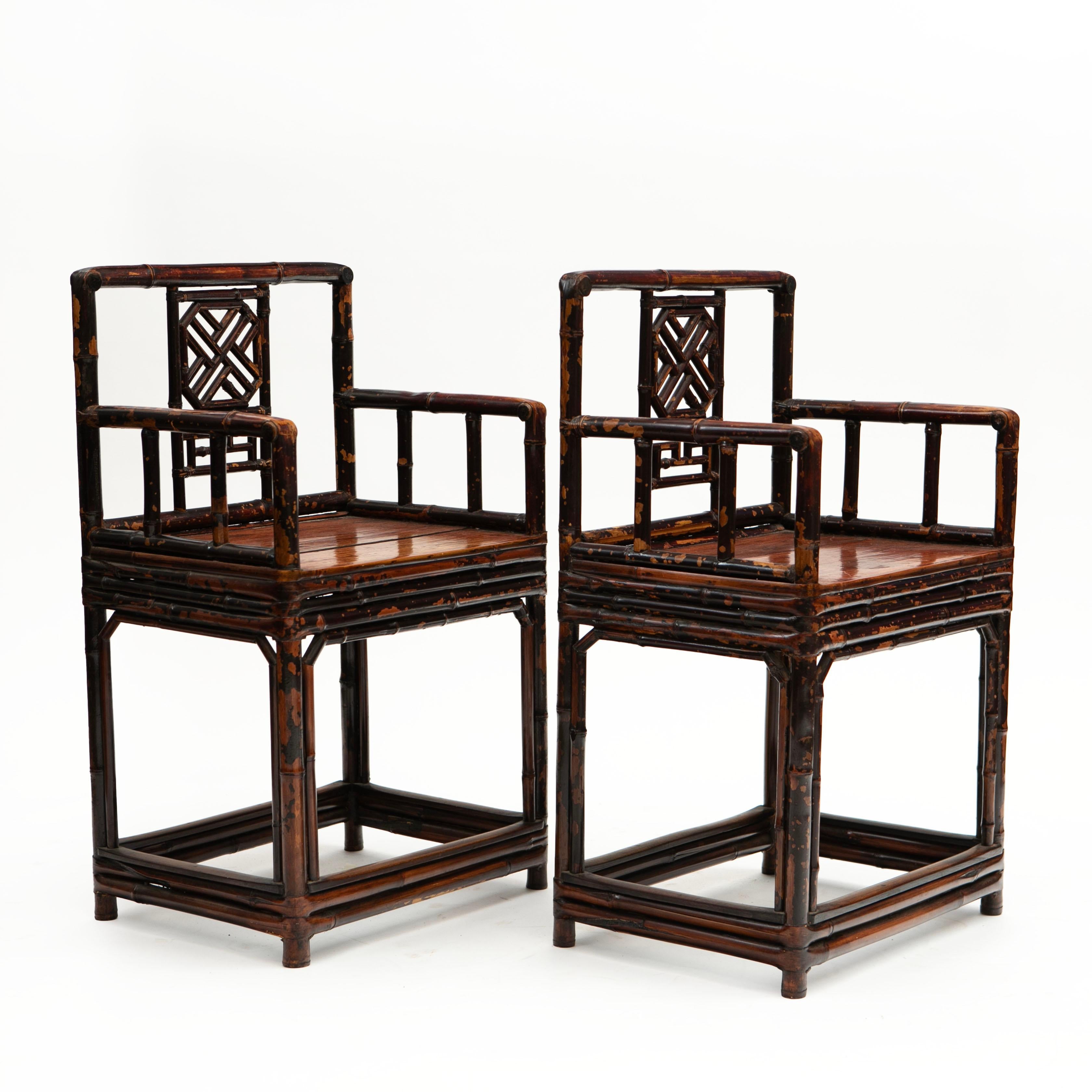 Pair of Chinese Qing period bamboo arm chairs with plain flat elm wood seat. Backrest with typical Chinese geometrical fretwork patterns.
Both chairs has a nice burgundy lacquer with beautiful natural age-related patina highlighted by a clear