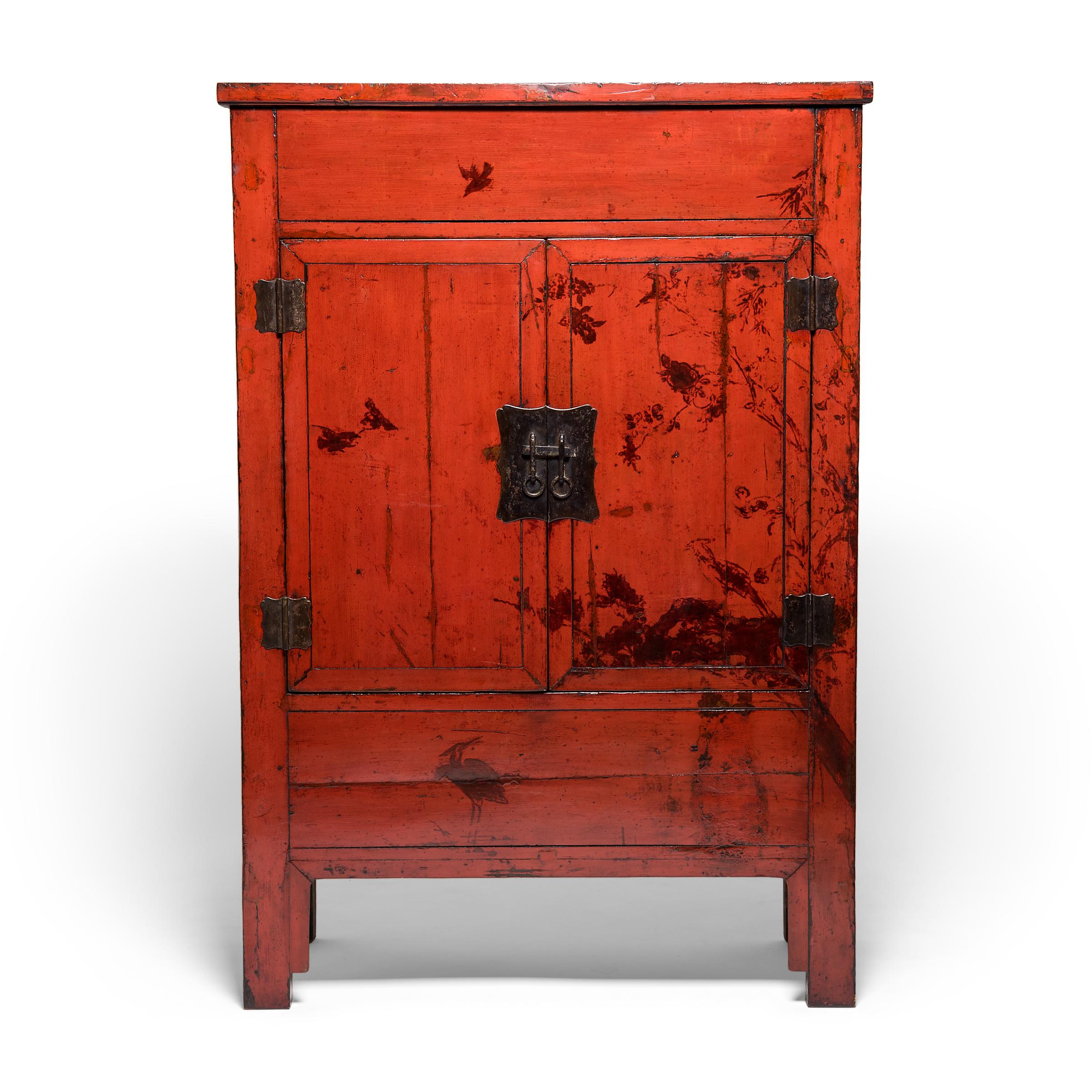 This pair of early 19th century red lacquer cabinets is an extraordinary find. When placed beside each other, what remains of the finely-painted decoration comes together to form a single scene of a tree branching out over a pond with swimming ducks