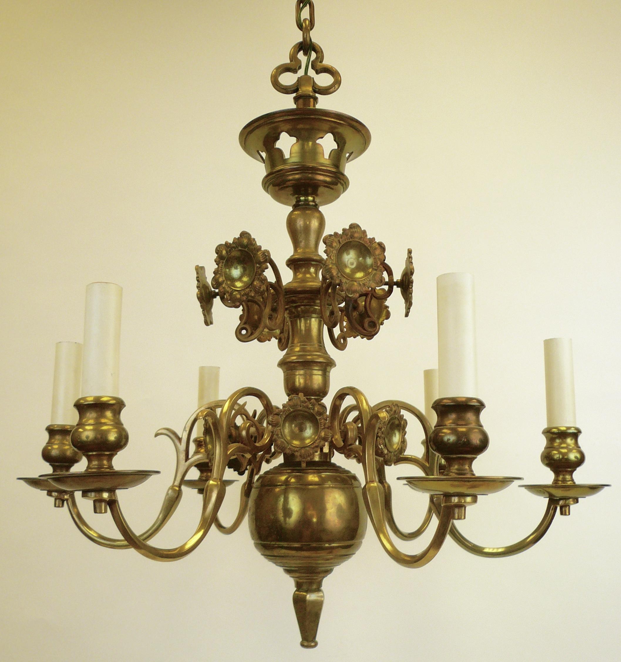 This handmade pair of 17th century Dutch style chandeliers feature scrolled arms and floral form reflectors. These chandeliers were originally retailed by Edward F. Caldwell & Company
There are four matching three arm sconces also available.