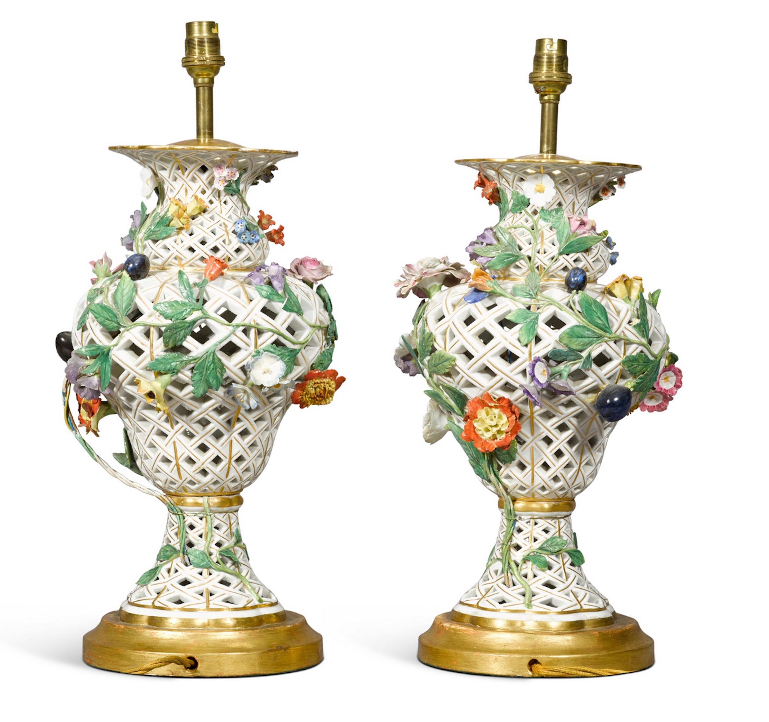 A rare pair of Continental porcelain table lamps, probably Samson in the Meissen style, 19th century of baluster form, pierced with a trellis pattern and applied with fruits and flowers, now mounted as a lamp with a hand gilded turned