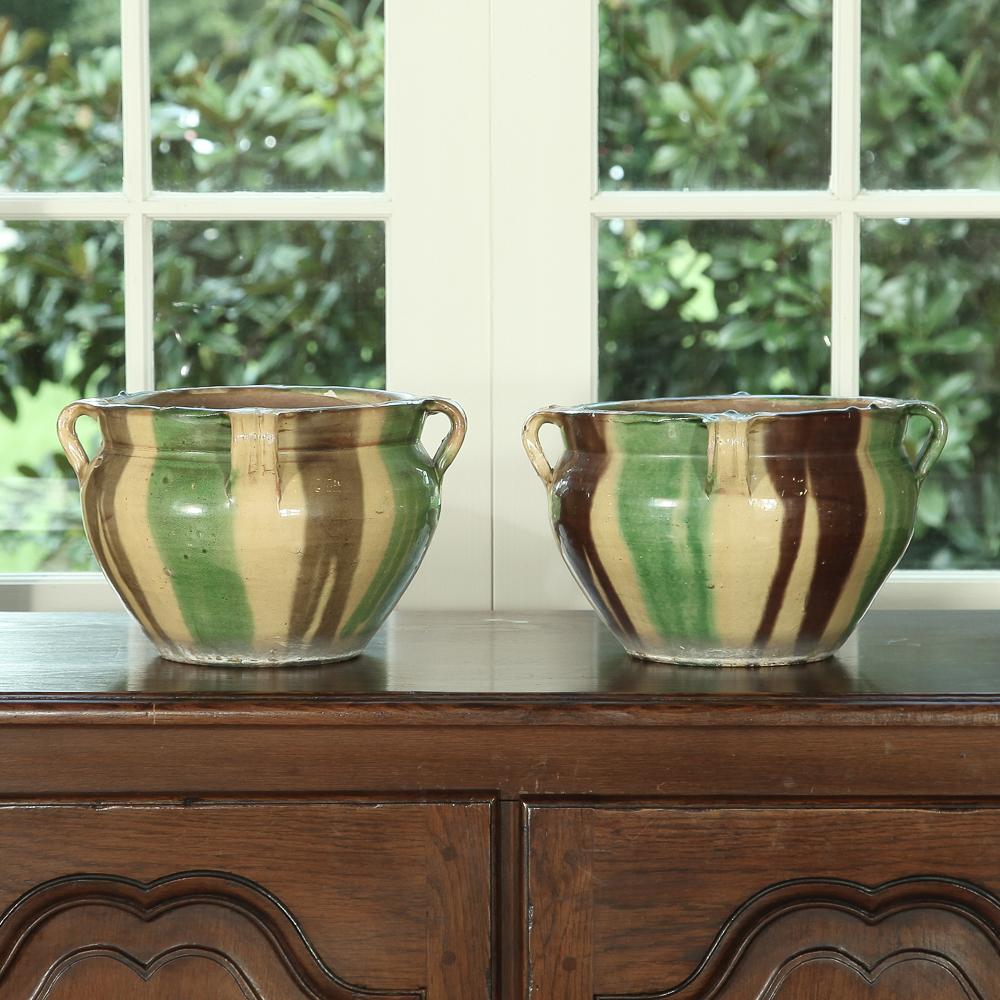 Charming pair of 19th century Country French earthenware jardinières, hand glazed in traditional greens, yellows and browns of Provence rare to survive together. Perfect for the gardener. Priced as pair,
circa 1890s.
Each measures 8 height x 13 in