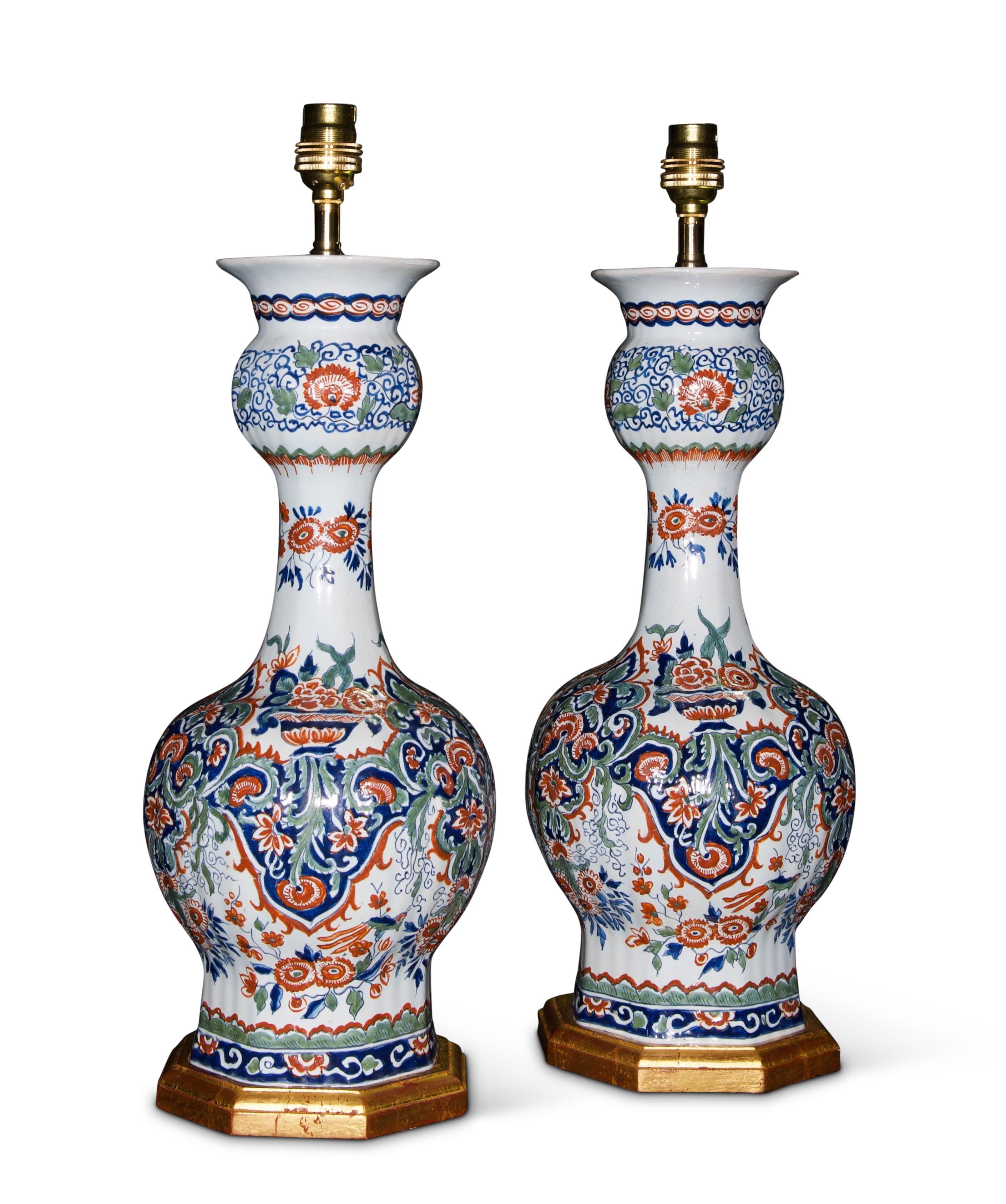 A fine pair of mid 19th century Dutch Delft vases painted in the Kashmiri palette. Of octagonal form, the decoration features stylised flowers in panels painted with colours which are soft, yet vibrant. Iron red blossoms are set in a field of cobalt