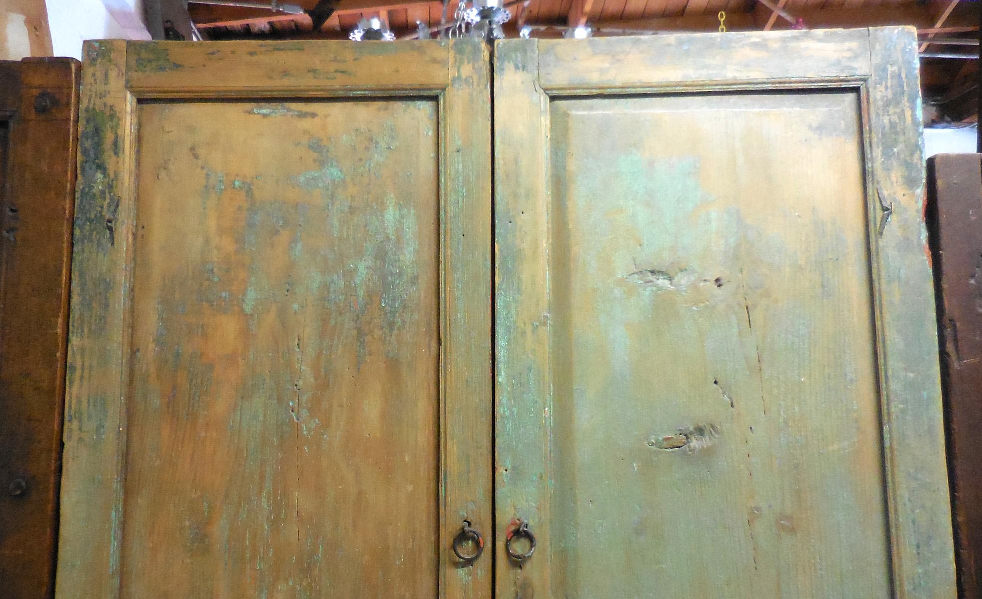 Beautiful pair of 19th century, antique doors with traces of old paint, green and red. Original, old hardware. 
One door has a red back side and the other a natural color with some red paint. Beautiful, old worn patina throughout.