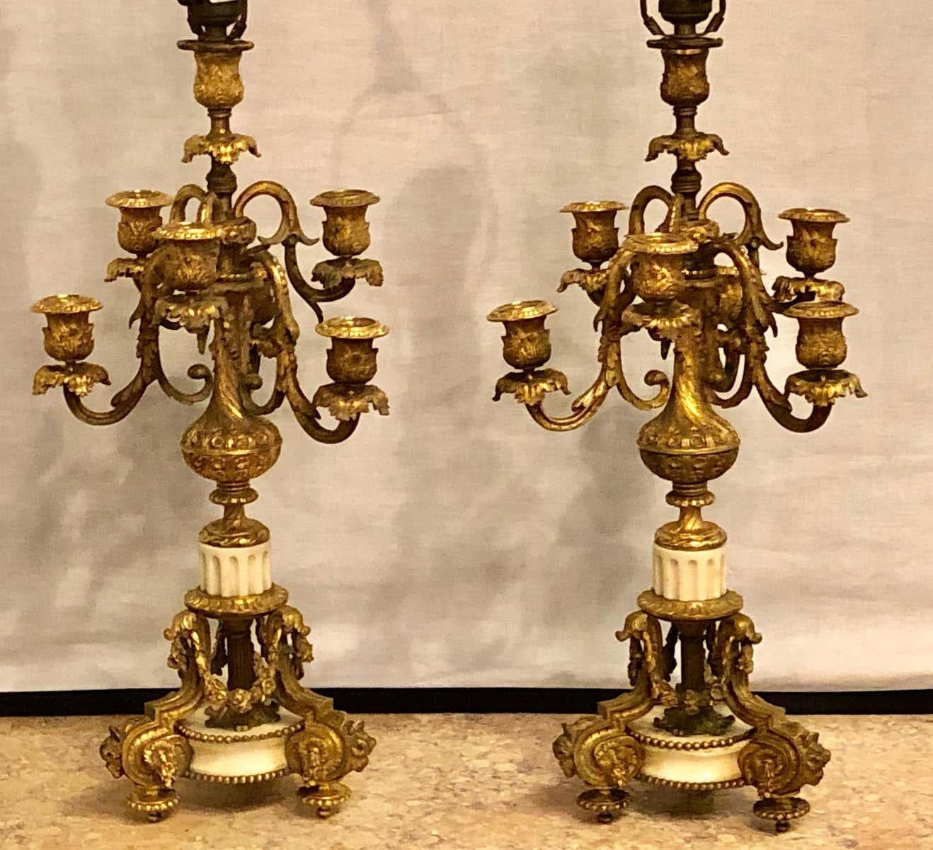 Pair of 19th century doré bronze 7-light marble base candelabras mounted as lamp. Each having bronze sabots leading to a white Carrara marble pedestal base that is bronze mounted with finely chased floral and swag design reminiscent of the early