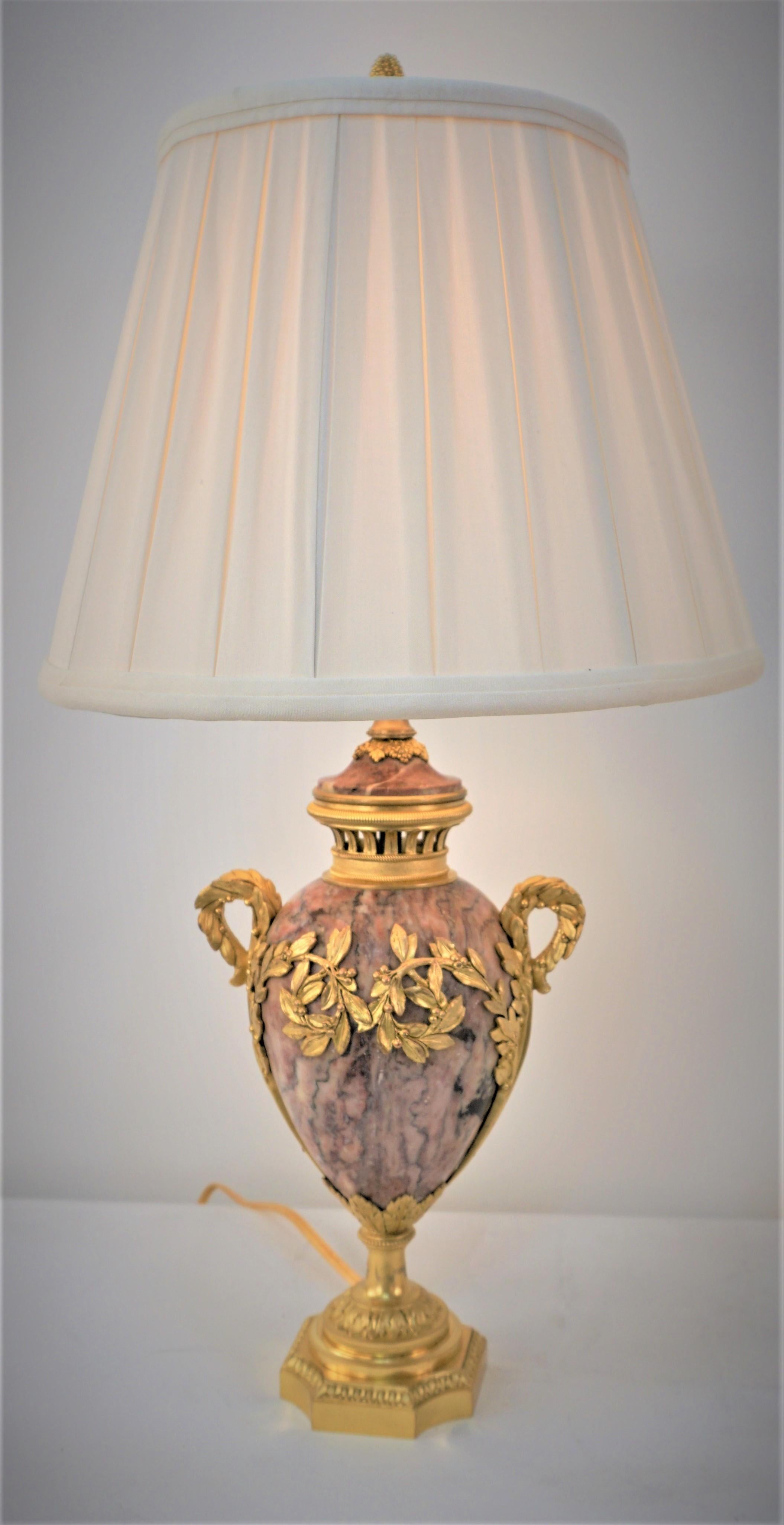 Pair of gilt bronze and textured pink marble urns that have been professionally electrified with 3way socked and fitted with box pleat silk lampshades.
Measurement: includes the lampshade.